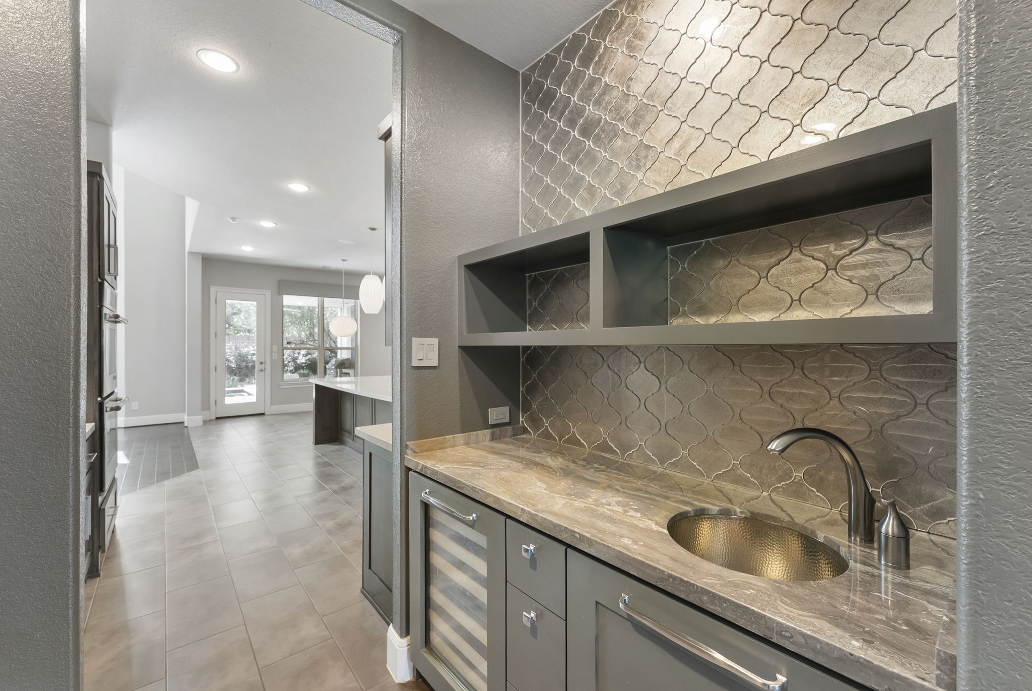 Custom wet bar featuring sleek cabinetry, a prep sink, and a built-in wine fridge.