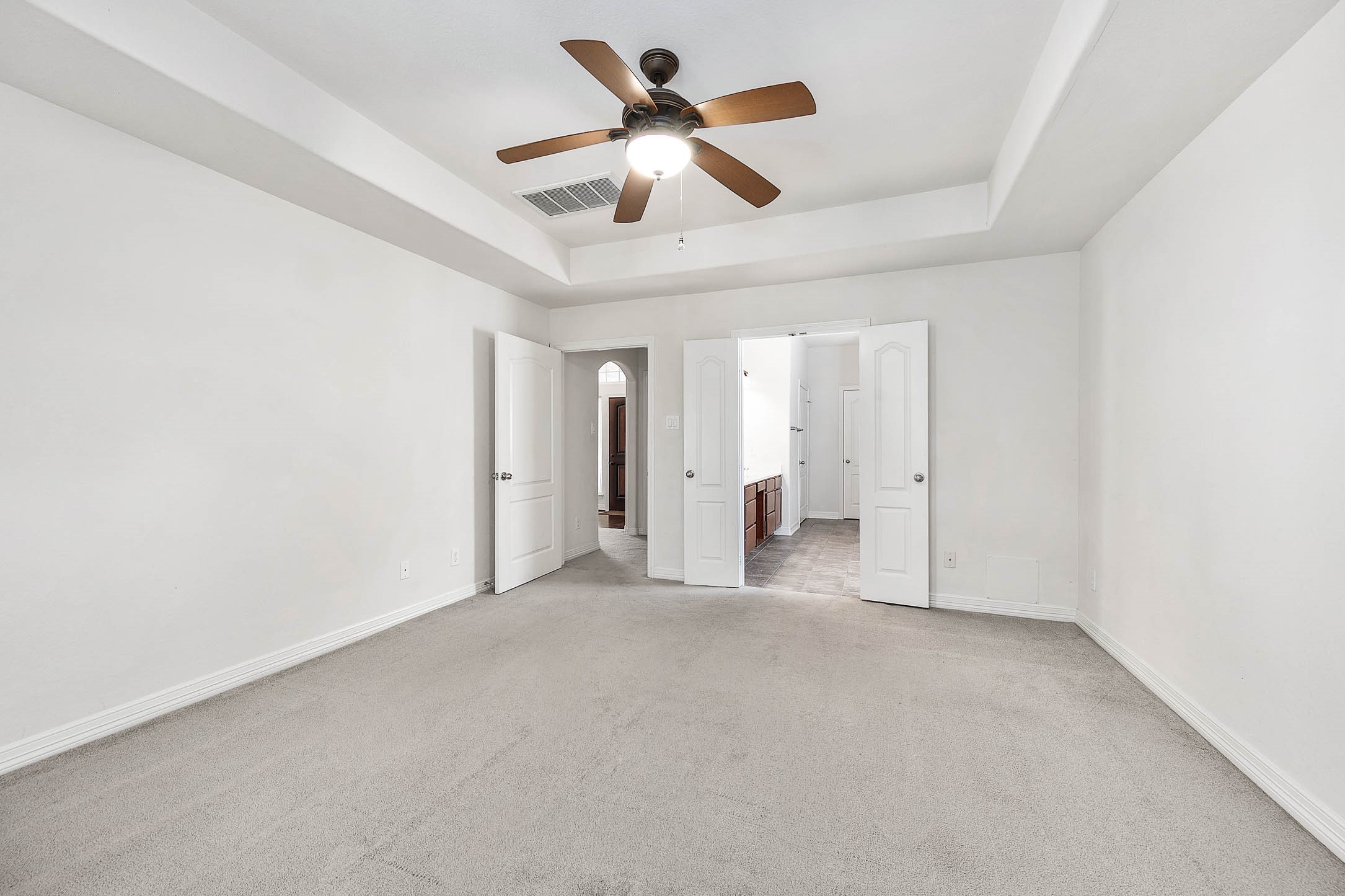 Step into the spacious primary suite with seamless access to a luxurious bathroom, offering both comfort and convenience.