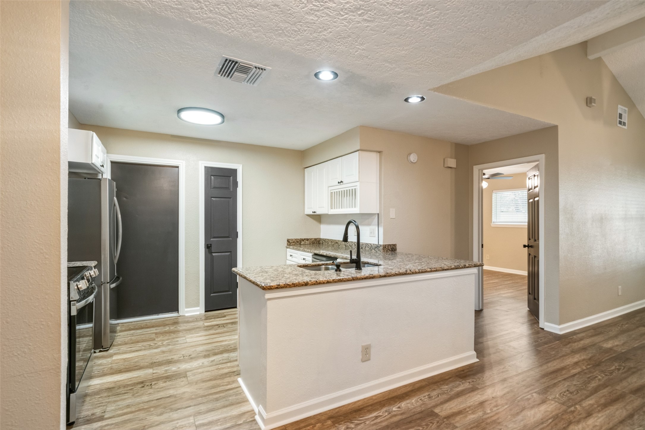 Kitchen, with new stainless steel appliances, is open to dining and living areas.