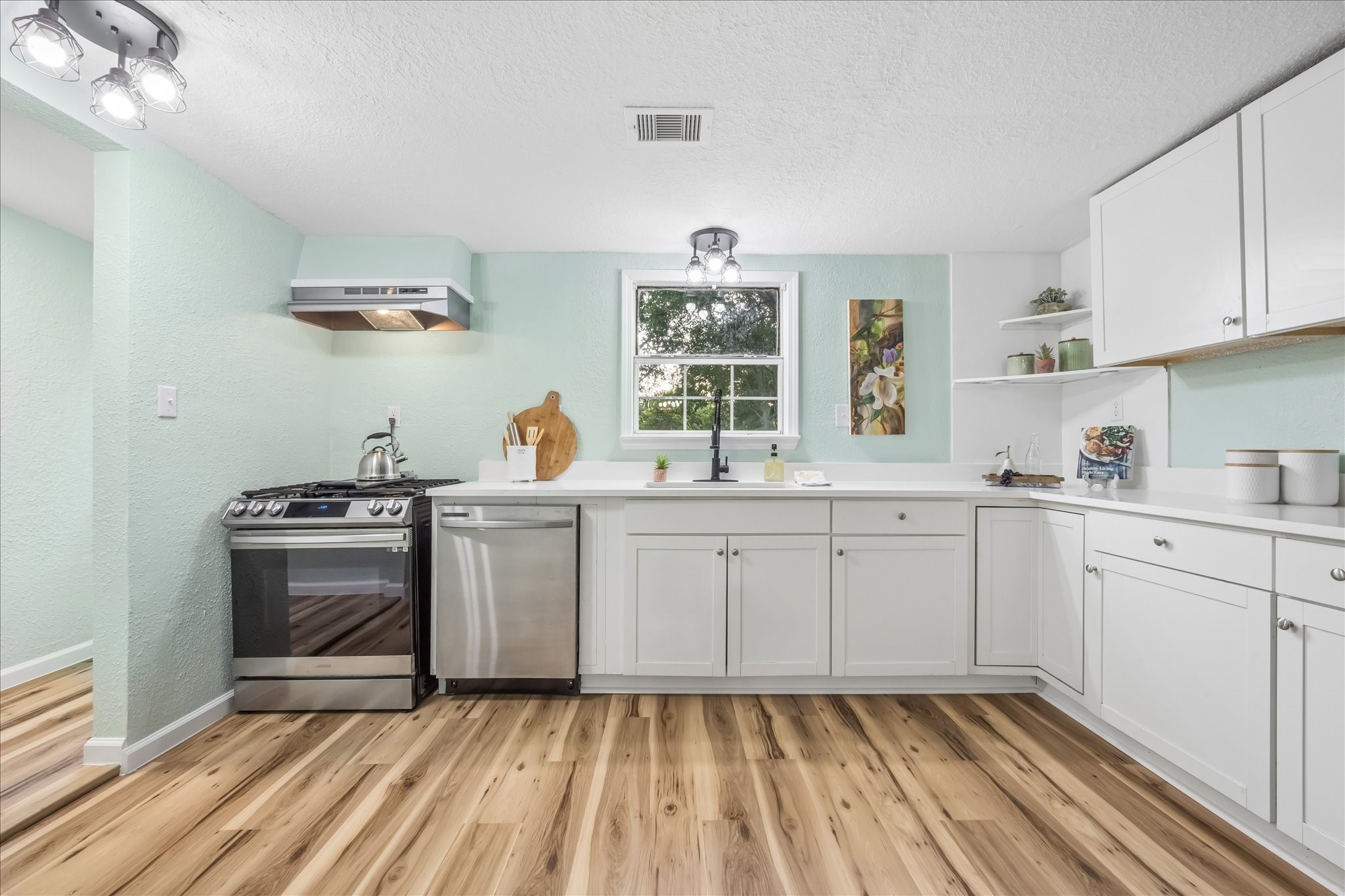 Remodeled kitchen with quartz countertops and stainless steel appliances.