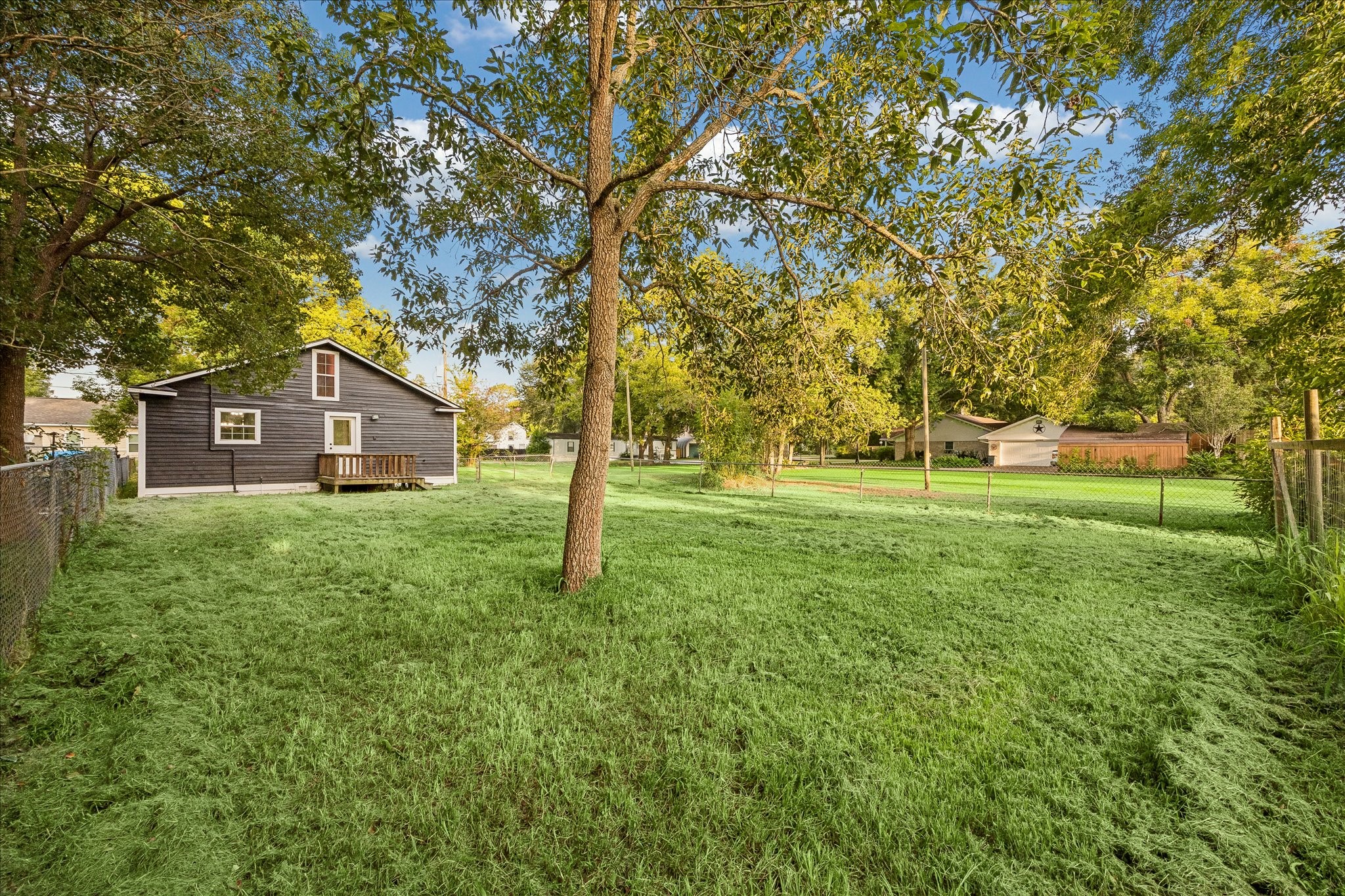 Mature trees frame the home and large yard.