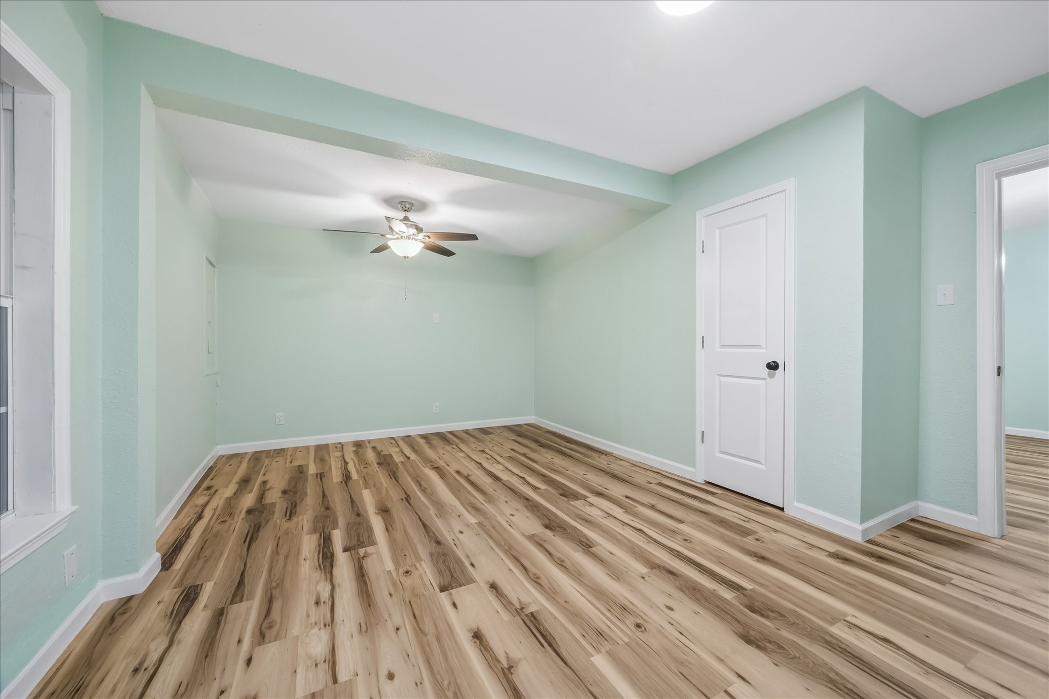 Light-filled bedroom with fresh paint and new flooring.