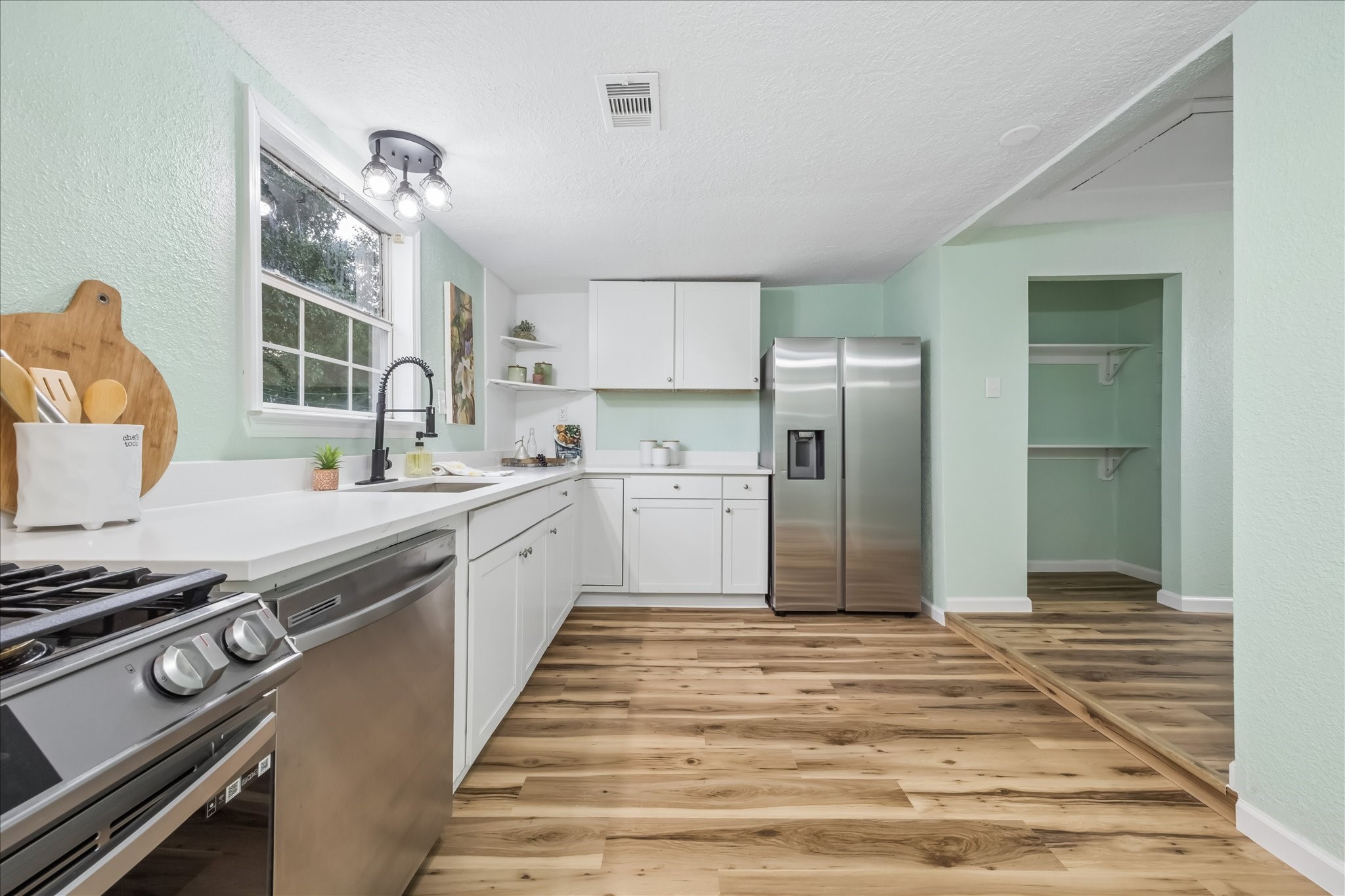 White cabinetry, gas cooking, and a spacious pantry.