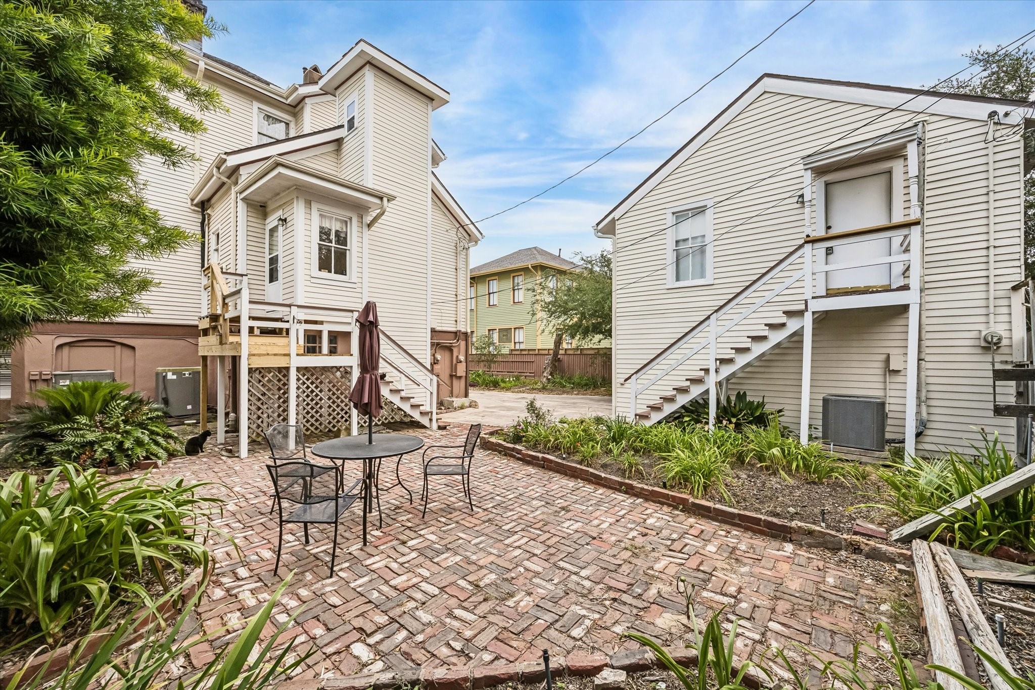 A view of the back of the house from the back patio. An elevator was added to the back of the house in 2011. Stairs lead to the garage apartment on the right and to the kitchen in the main house on the left.