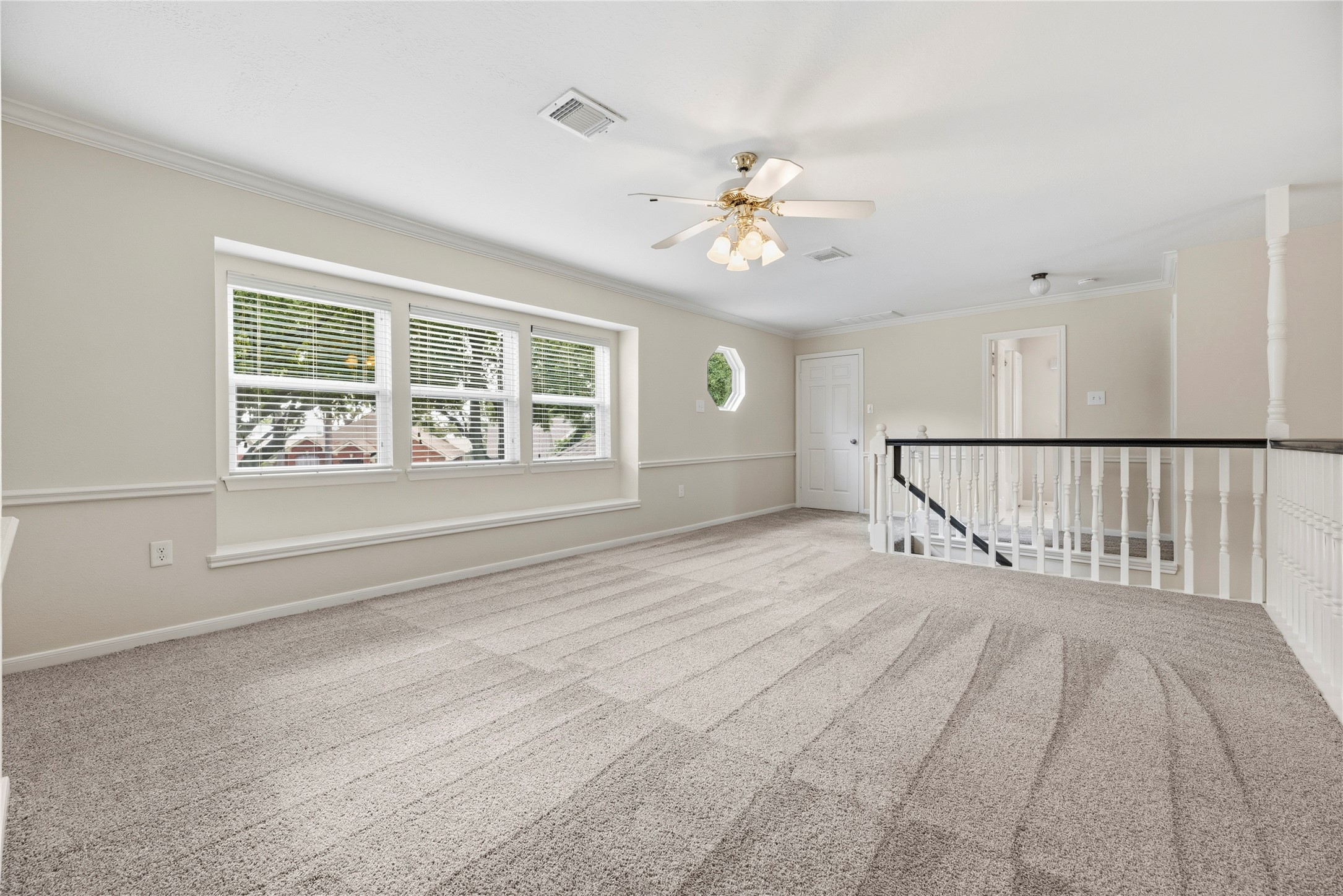 Large upstairs gameroom/flex area features plush carpeting and lots of natural light, creating a comfortable and inviting atmosphere.
