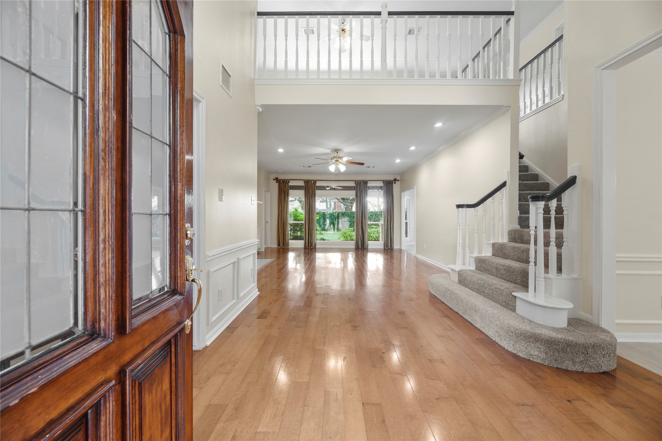 Inviting entryway with engineered hardwood floors and abundant natural light flowing from large windows overlooking lush backyard. Inviting entryway with engineered hardwood floors and abundant natural light flowing from large windows overlooking lush backyard.