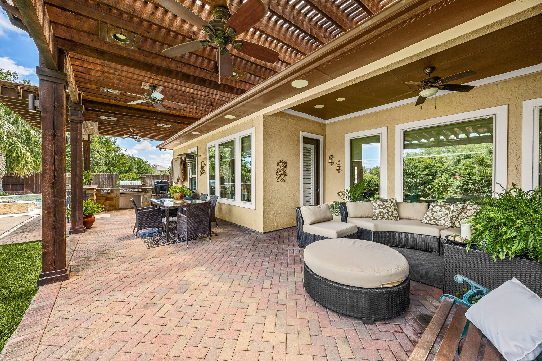 The ultimate outdoor living space! Dual ceiling fans, a sprawling brick paver patio, wood pergola, and lush tropical landscaping create a private oasis perfect for relaxing or entertaining all year long.
