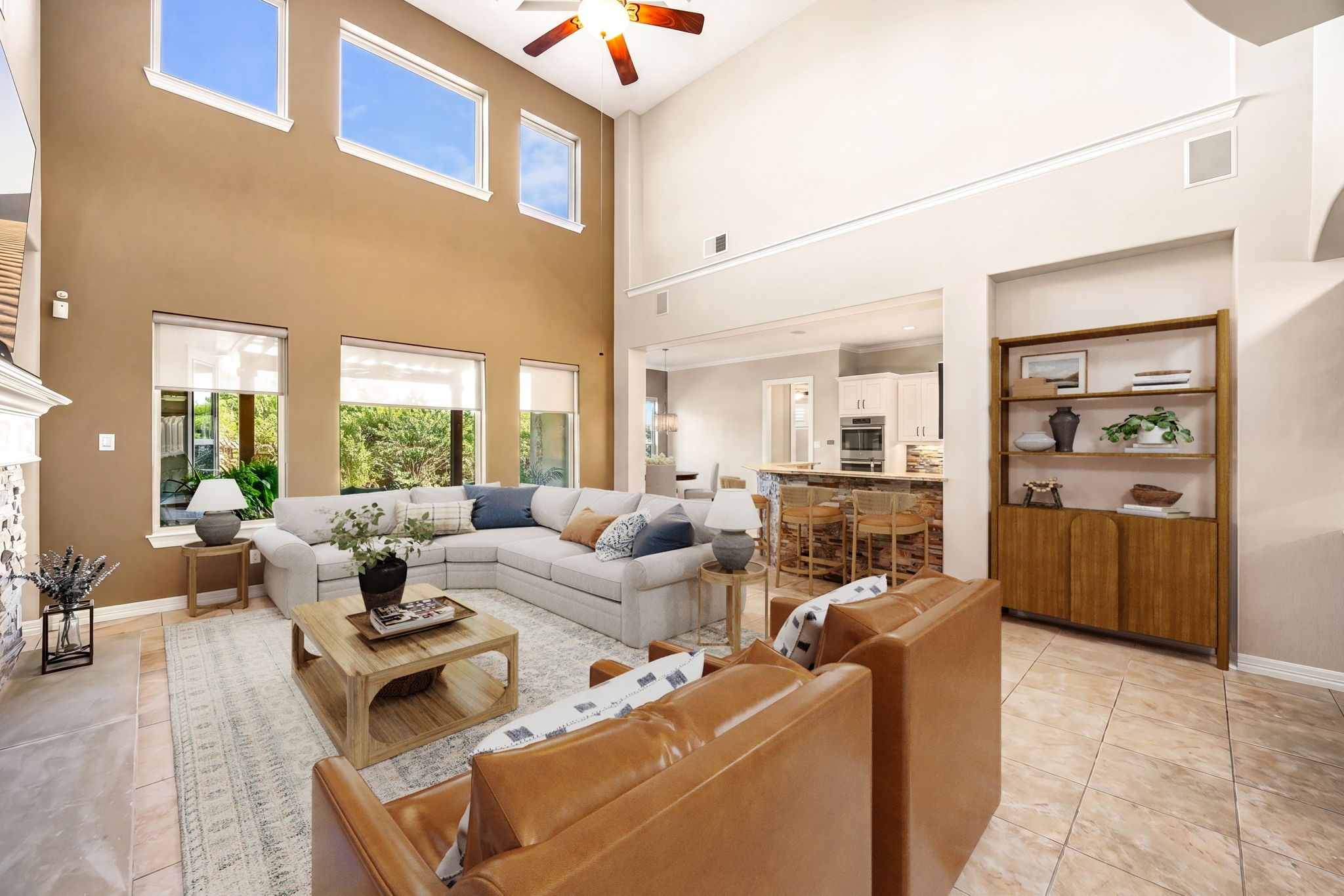 Cozy meets grand! This spacious living room features a dramatic stacked stone fireplace, built-in shelving, ceiling fan, wet bar, and soaring two-story ceilings, the ultimate space to relax and unwind. *Virtually Staged Cozy meets grand! This spacious living room features a dramatic stacked stone fireplace, built-in shelving, ceiling fan, wet bar, and soaring two-story ceilings, the ultimate space to relax and unwind. *Virtually Staged