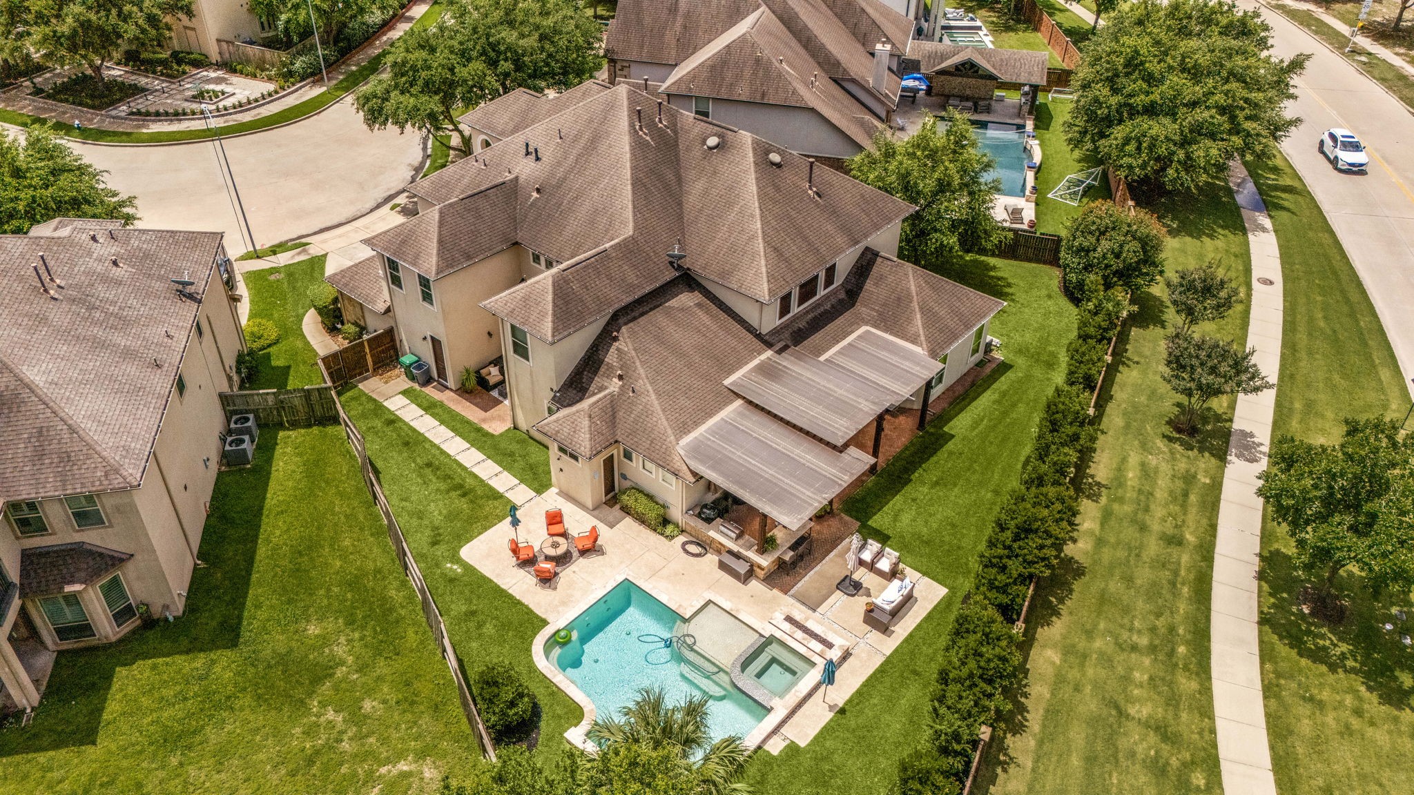 This incredible aerial shot showcases the expansive lot, pool and spa, covered pergola, outdoor kitchen, and lush green yard, all nestled on a prime cul-de-sac in Cinco Ranch Southwest.