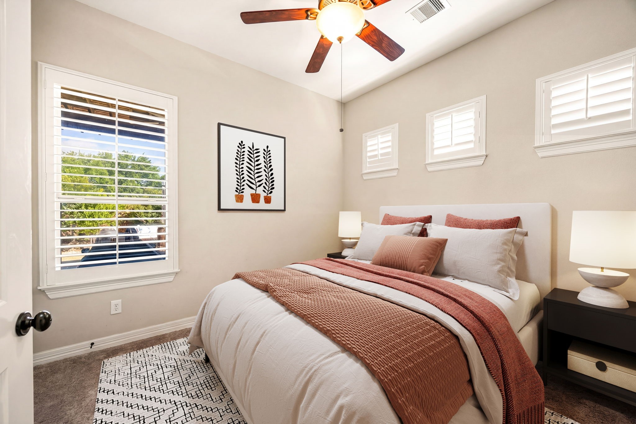 The perfect guest retreat! This cozy first floor bedroom features plush carpet, plantation shutters, vaulted ceiling, and a ceiling fan, comfortable and inviting for any guest. *Virtually Staged