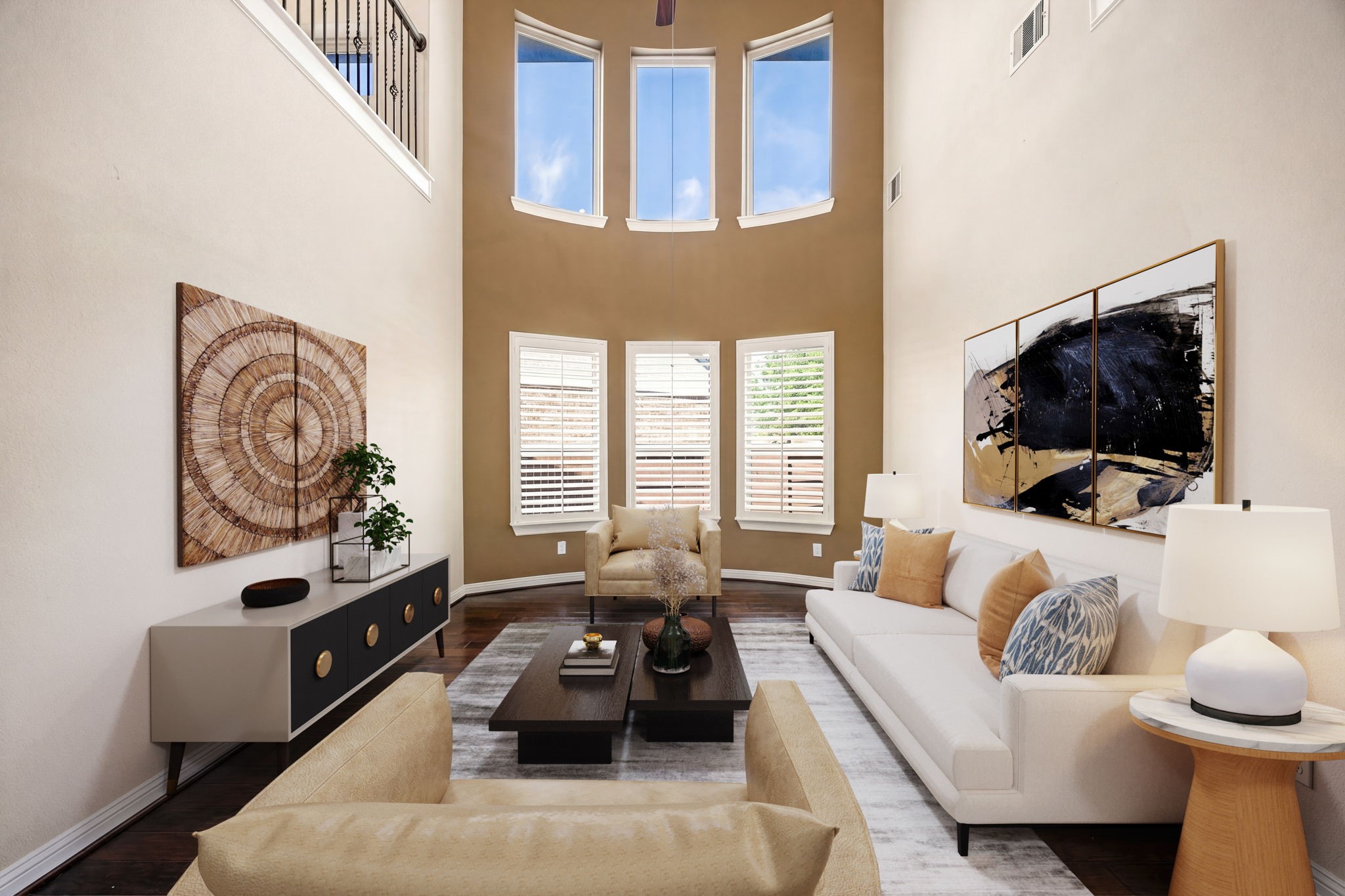 Breathtaking two-story formal living room with soaring ceilings, rich hardwood floors, and floor-to-ceiling windows that bathe the space in natural light. Plantation shutters, a curved accent wall, and an iron-railed balcony overhead make this space as grand as it is inviting. *Virtually Staged Breathtaking two-story formal living room with soaring ceilings, rich hardwood floors, and floor-to-ceiling windows that bathe the space in natural light. Plantation shutters, a curved accent wall, and an iron-railed balcony overhead make this space as grand as it is inviting. *Virtually Staged