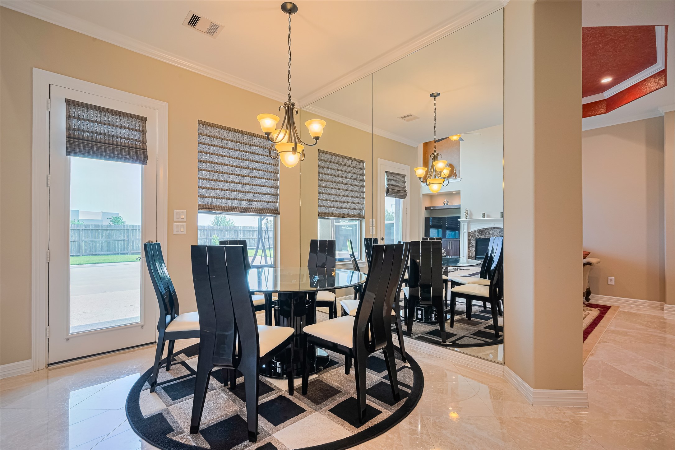 Bright breakfast area offering backyard access, a statement mirrored wall, and a relaxed setting for everyday dining.