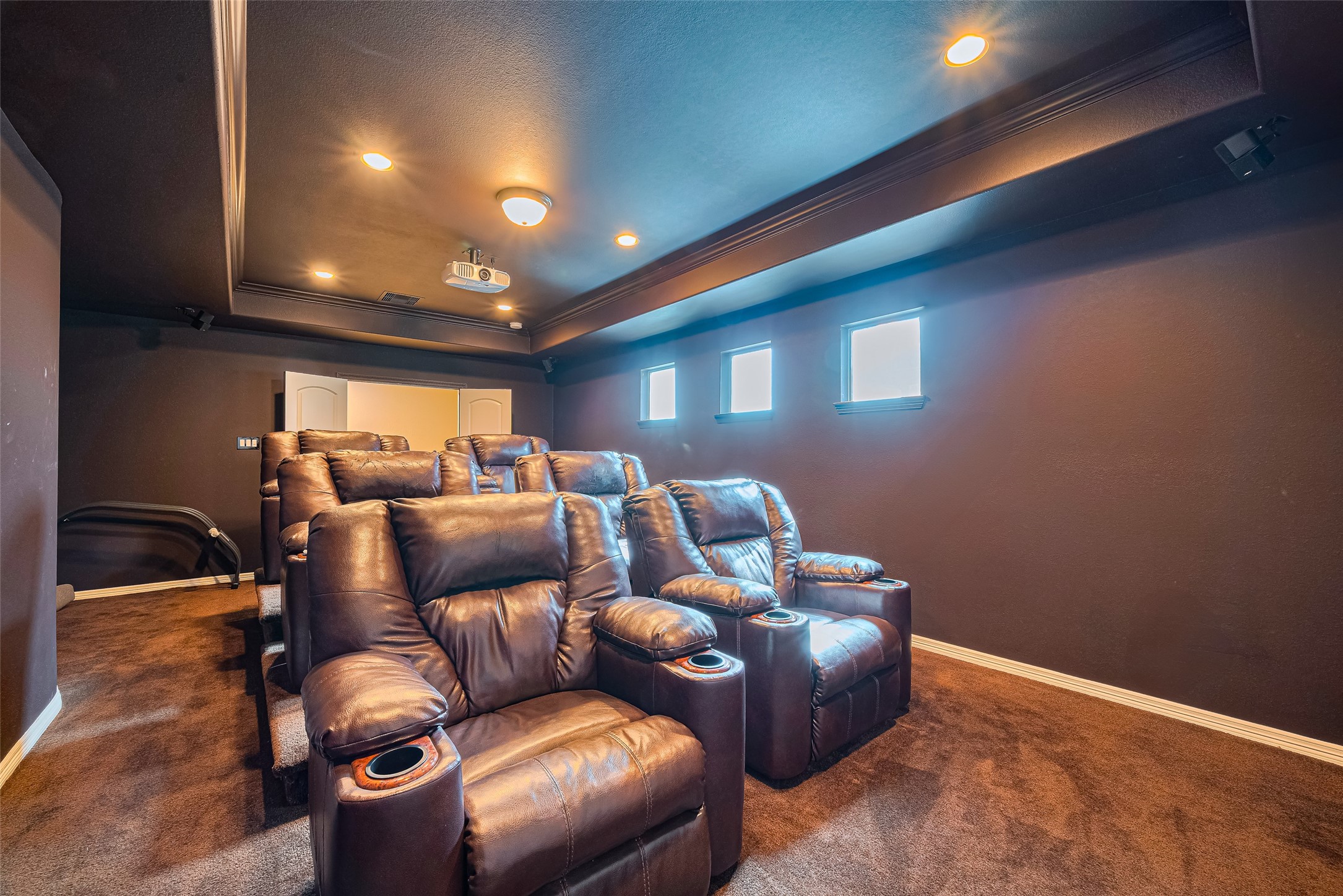 Reverse theater view showcasing plush reclining seats arranged across multiple tiers beneath recessed lighting for a true cinematic experience.