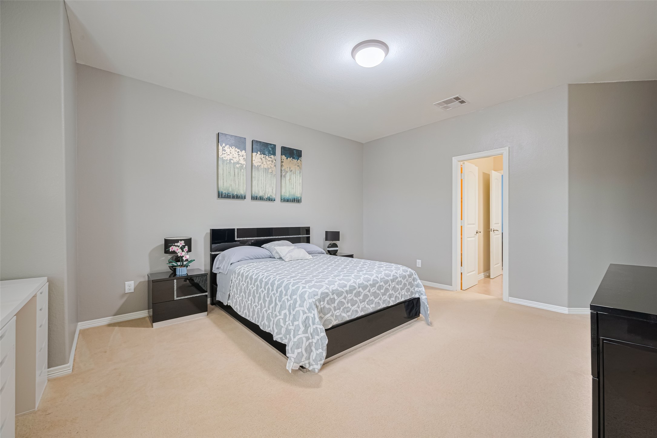 Another view of the spacious third bedroom, highlighting the generous layout, neutral finishes, and comfortable sleeping area.