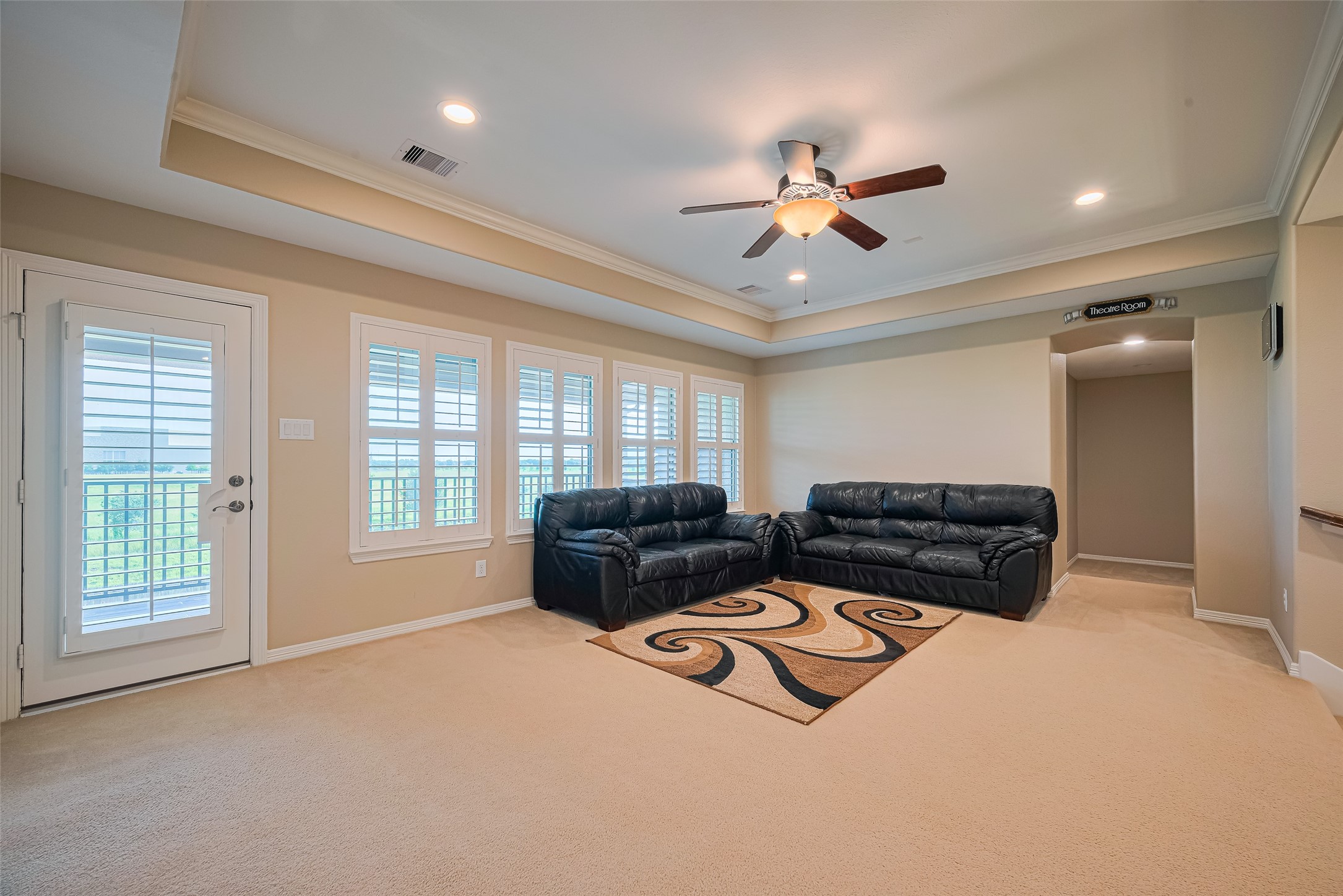 Alternate game room angle revealing balcony access, abundant natural light, and a dedicated entrance to the adjoining media room.