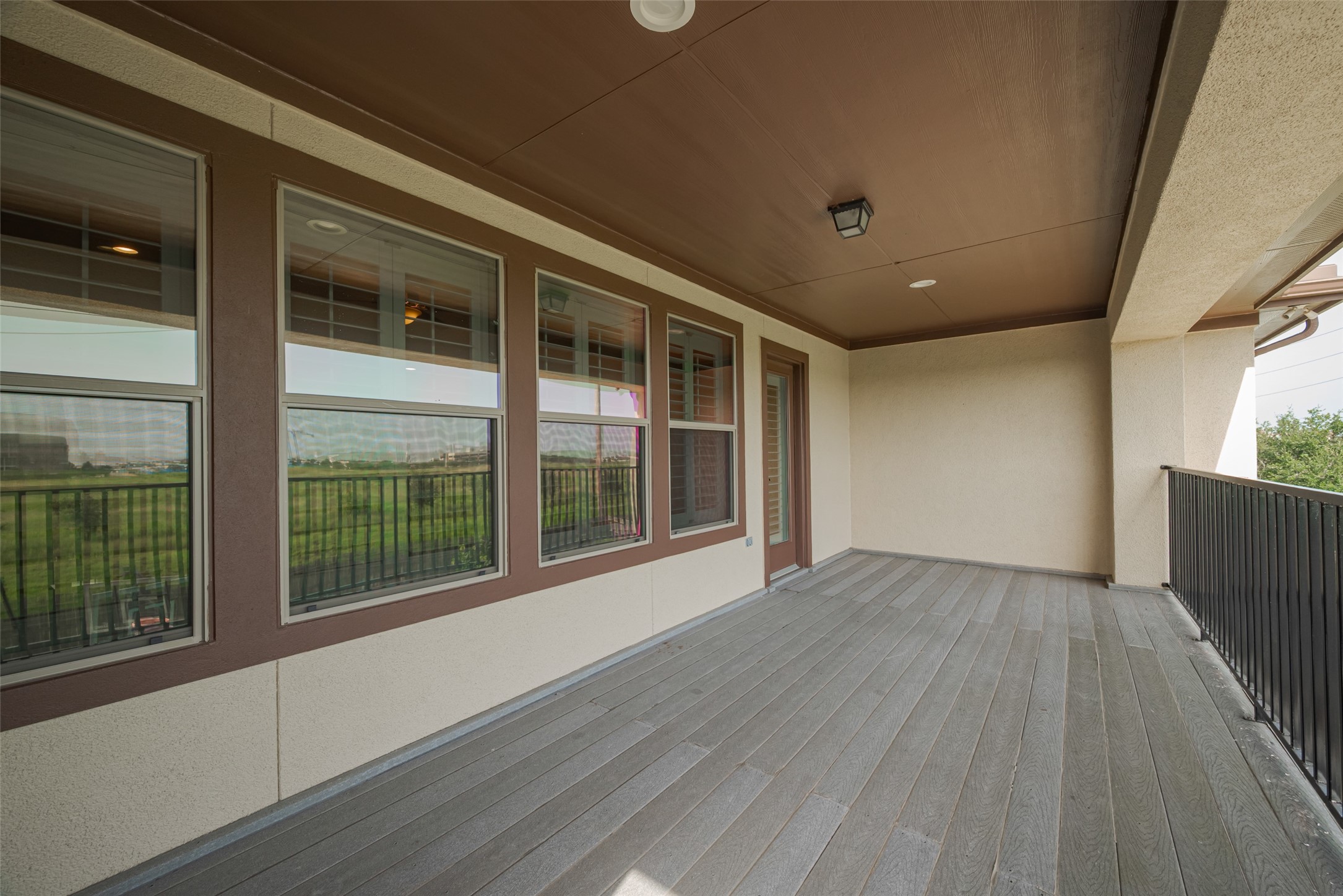 Spacious covered balcony offering ample room for outdoor seating and relaxation with open views beyond.