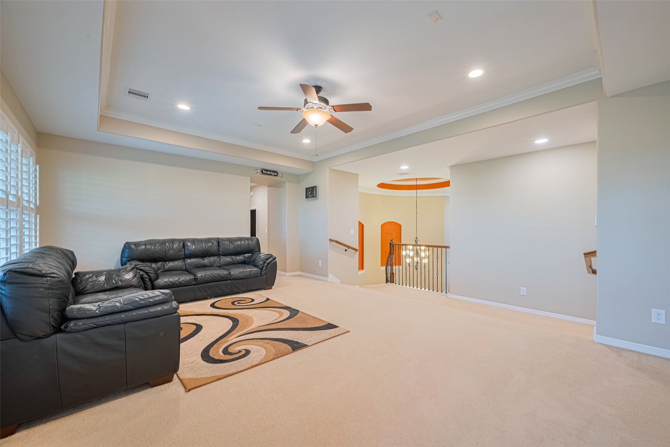 Reverse game room view highlighting the open upstairs landing, tray ceiling, and easy connection to the media room.