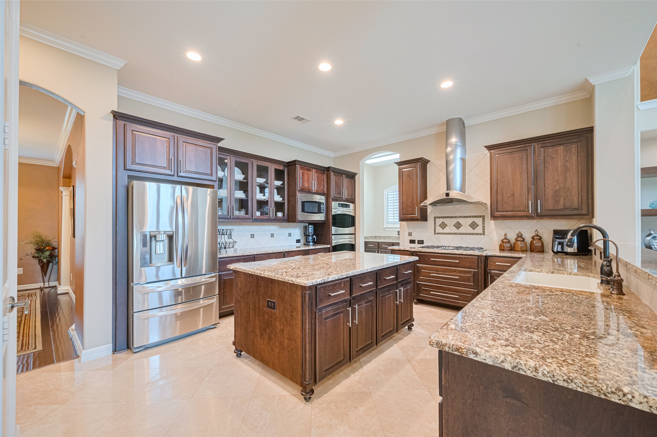 Gourmet kitchen equipped with granite countertops, abundant custom cabinetry, stainless steel appliances, and a generous center island.