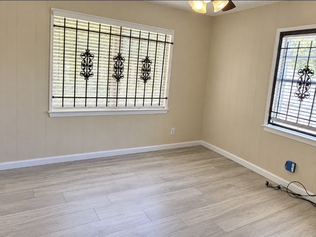 Bright room with elegant metal window grilles, warm beige walls, and modern wood-look flooring, creating a cozy and inviting atmosphere.