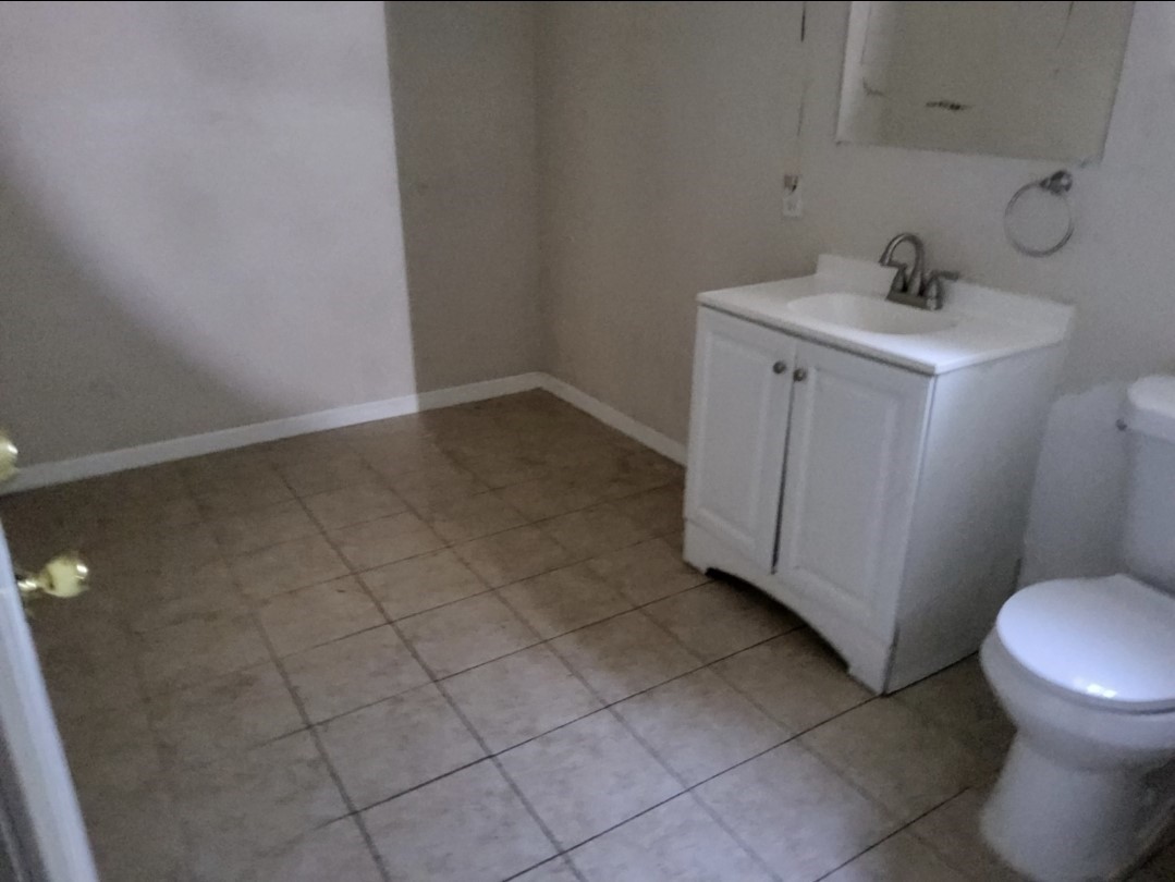Spacious bathroom featuring a modern vanity, tiled flooring, and sleek fixtures, offering a clean and functional space.