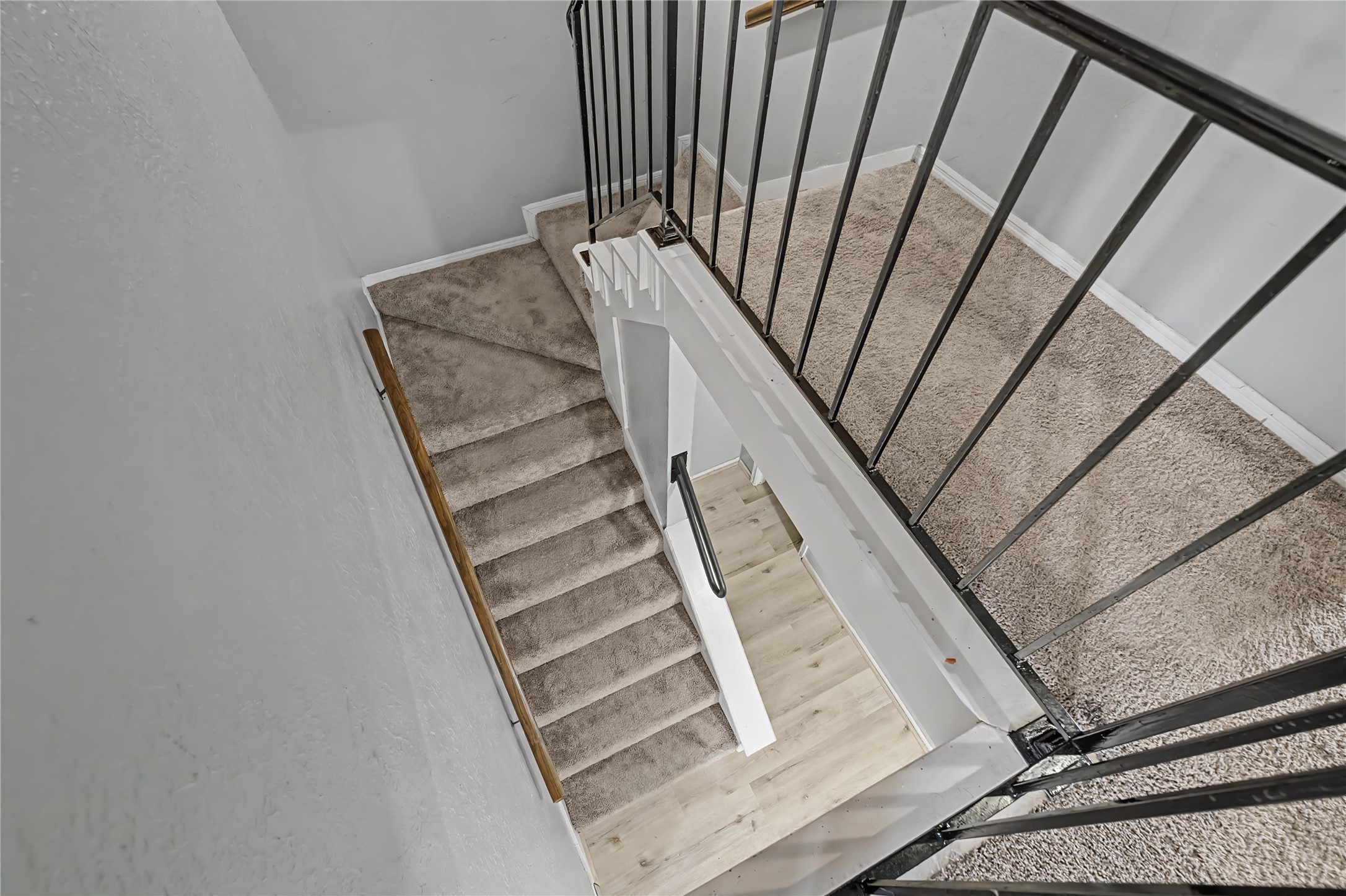 Carpeted staircase with metal railings connecting the upper and lower levels.
