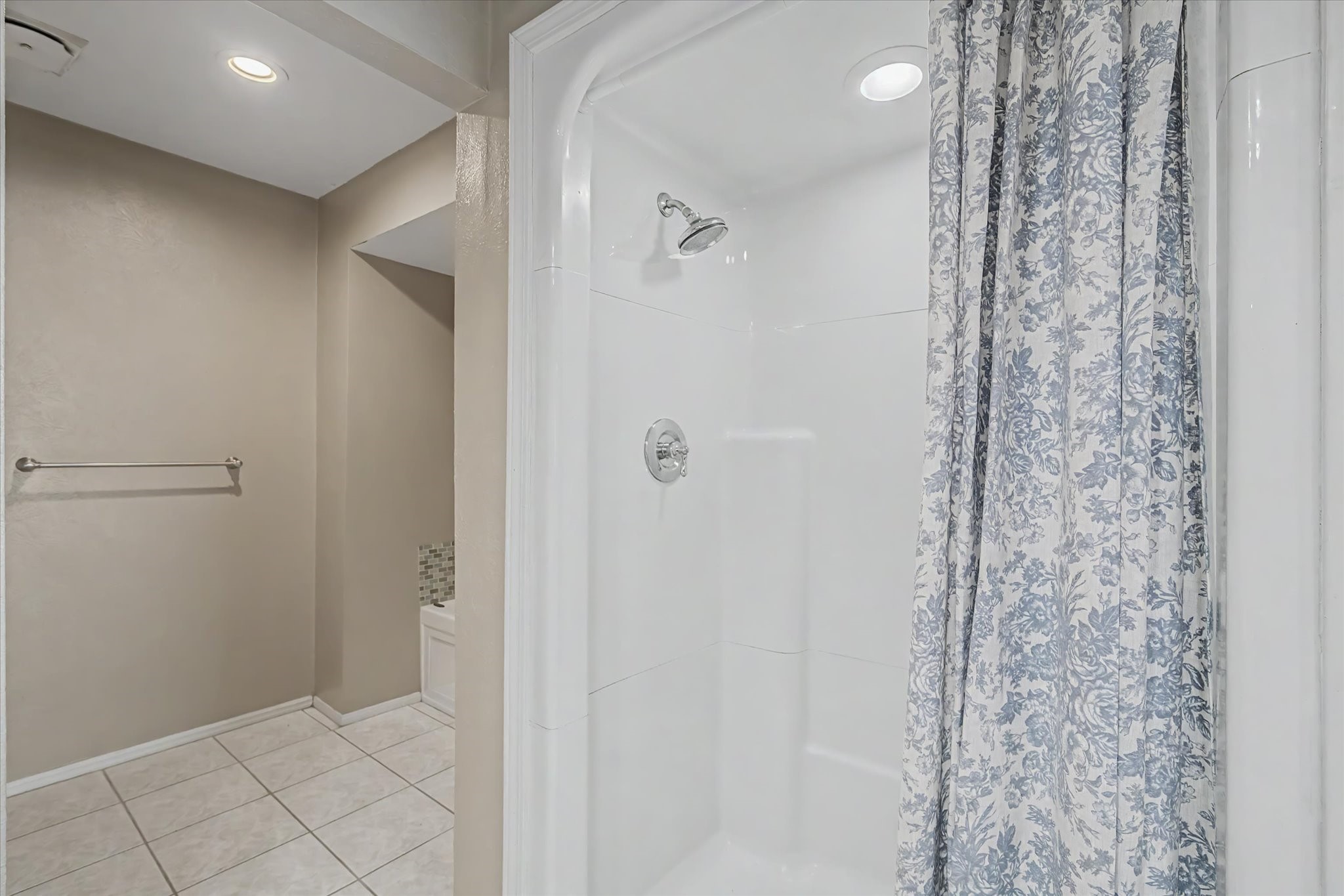 Separate shower with tile accents throughout.
