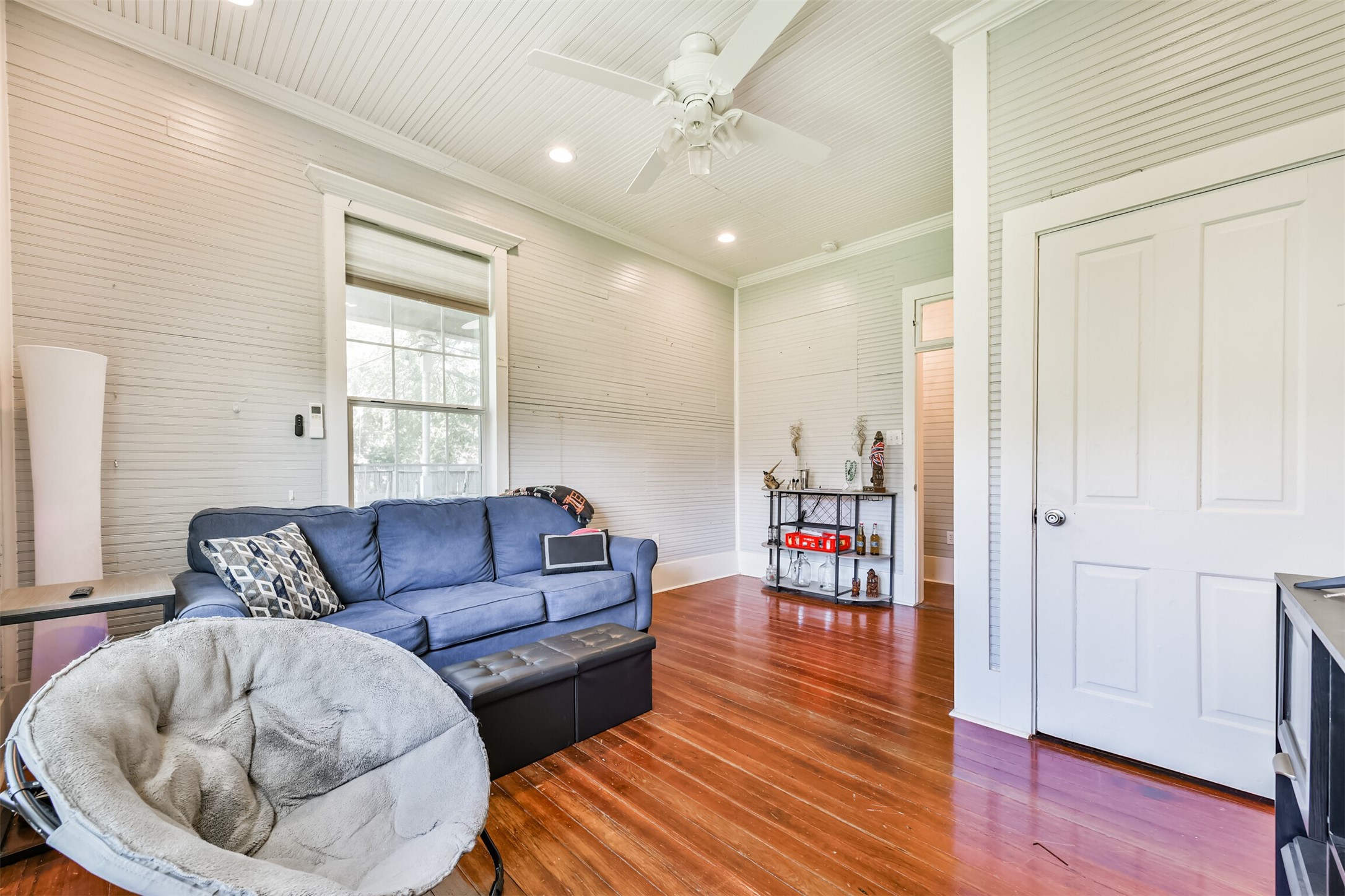 Another view of the flexible first-floor space with hardwood floors and abundant natural light.