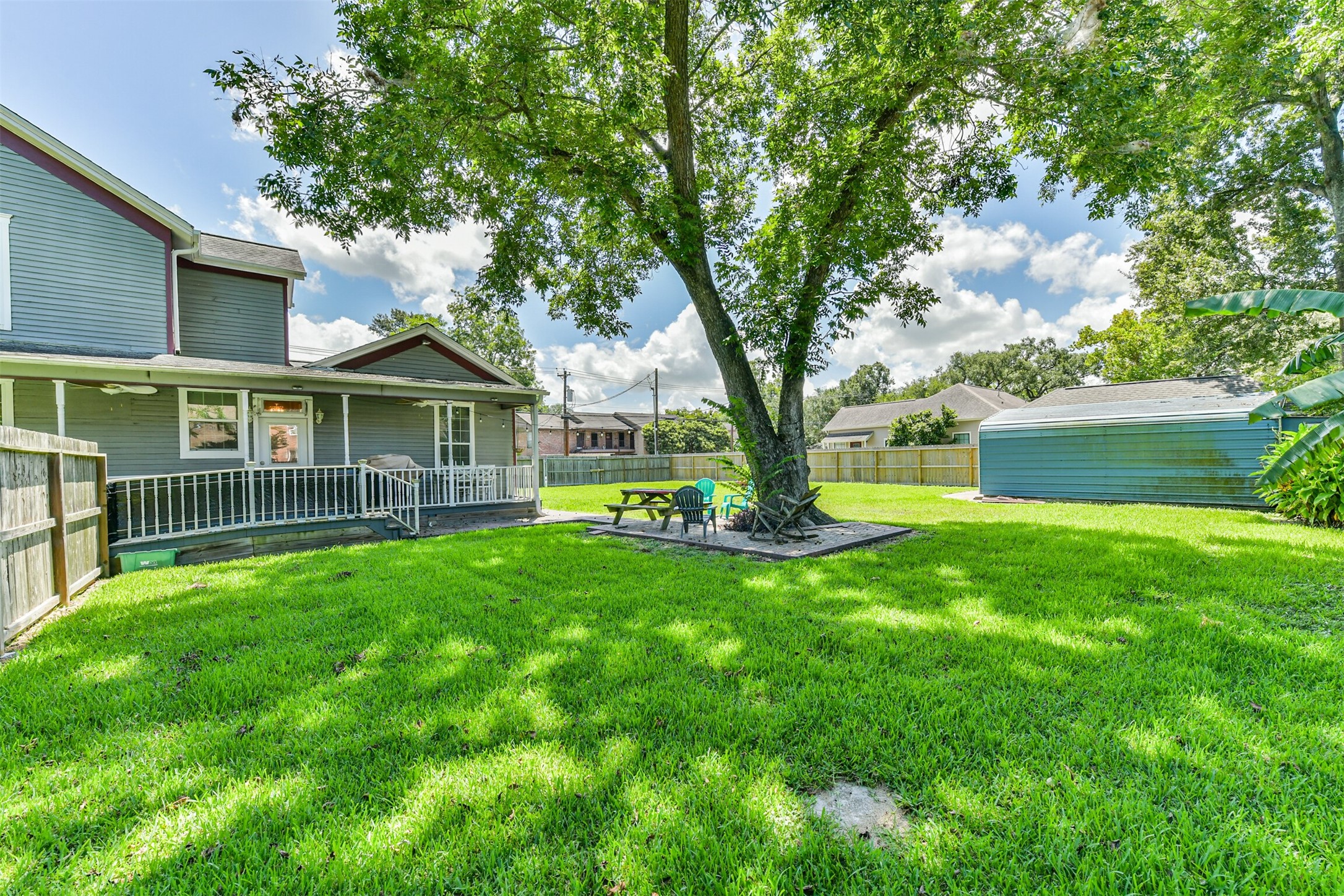 Mature shade trees and a sprawling lawn create a beautiful setting around this 1890 Alvin treasure.