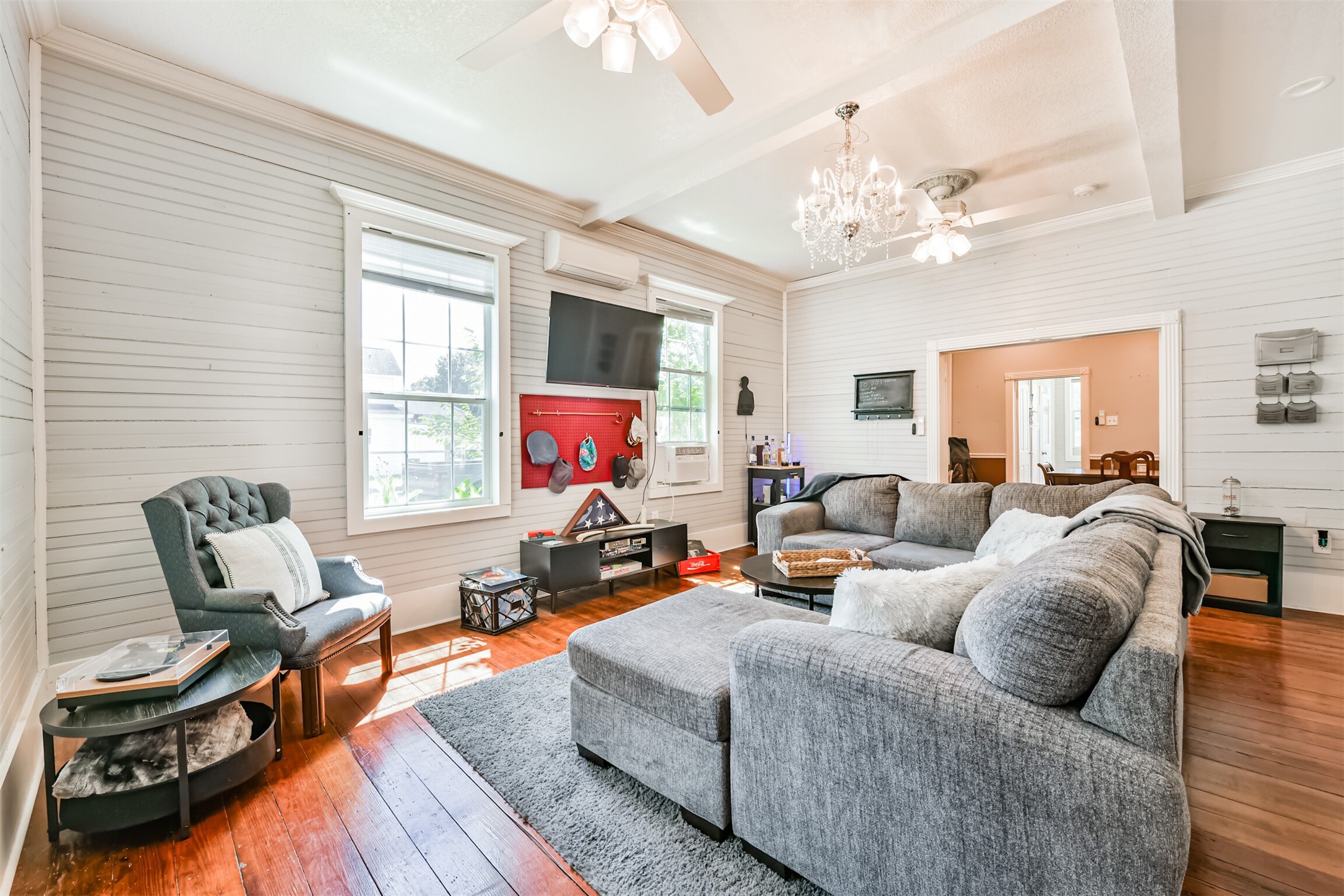 Spacious living area pairs 10' ceilings with beautiful original flooring and natural light. Spacious living area pairs 10' ceilings with beautiful original flooring and natural light.