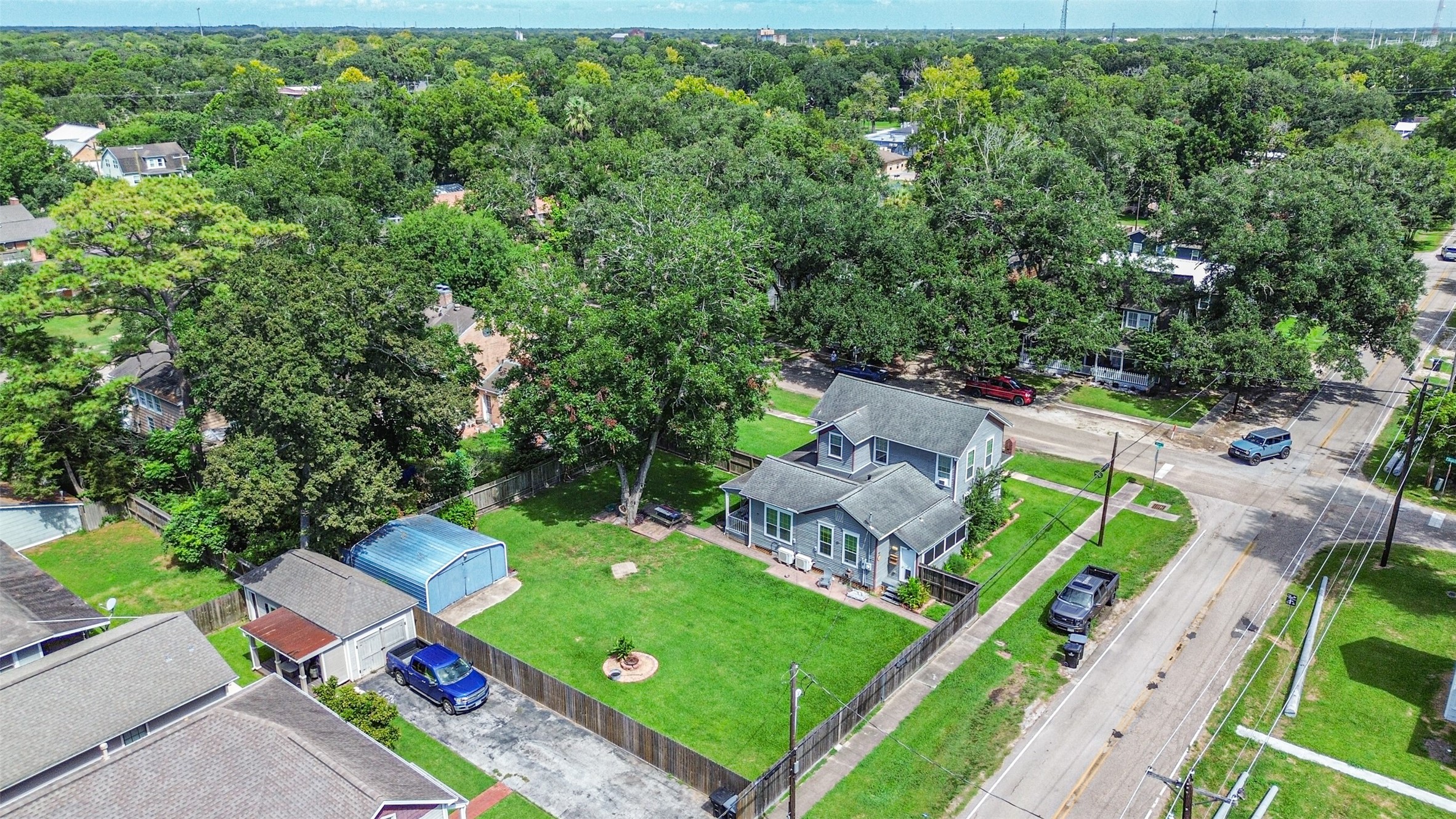 Aerial view showcasing the home, expansive lawn and prominent corner location.