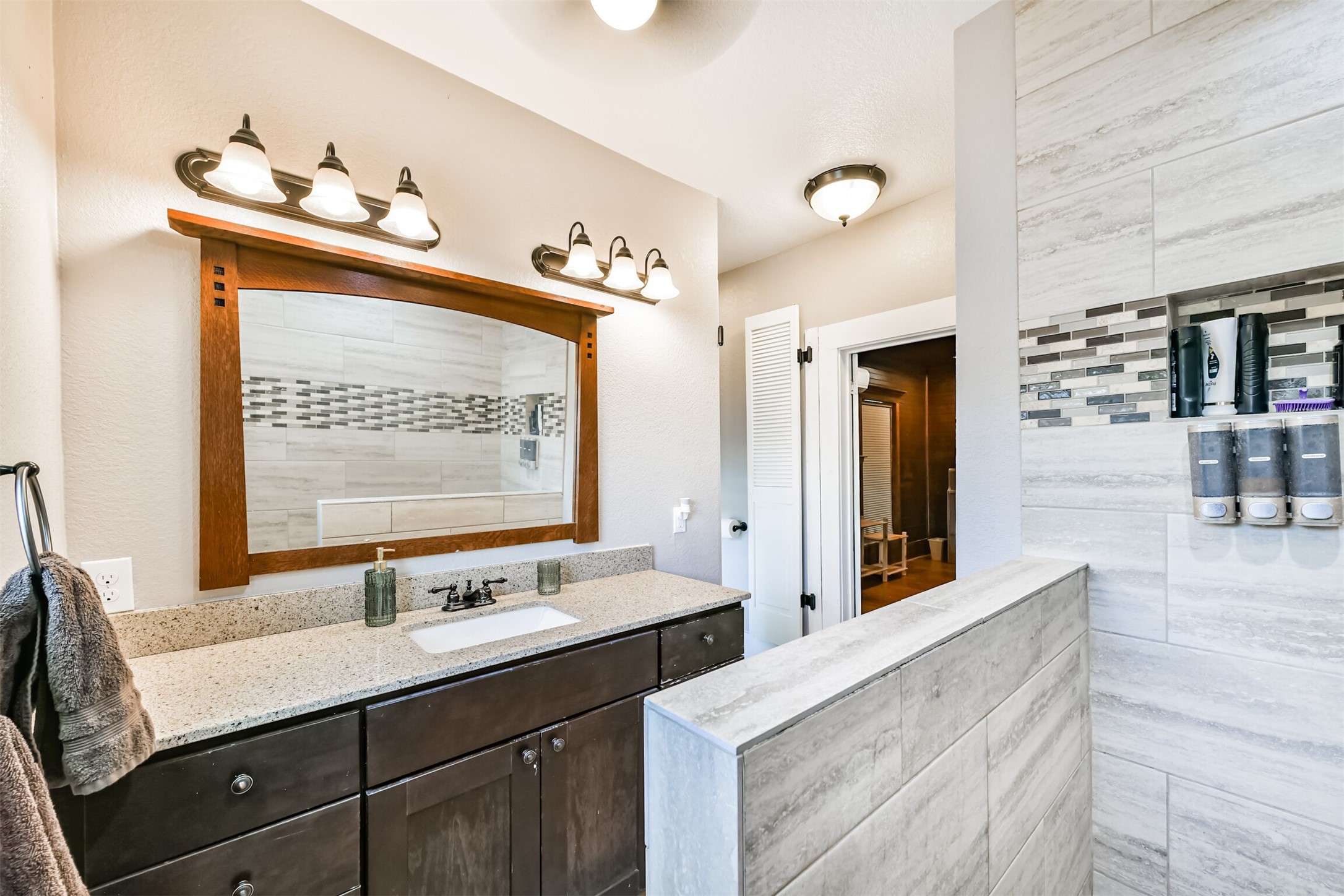 Updated vanity, generous counter space and stylish finishes complete the remodeled upstairs bath.