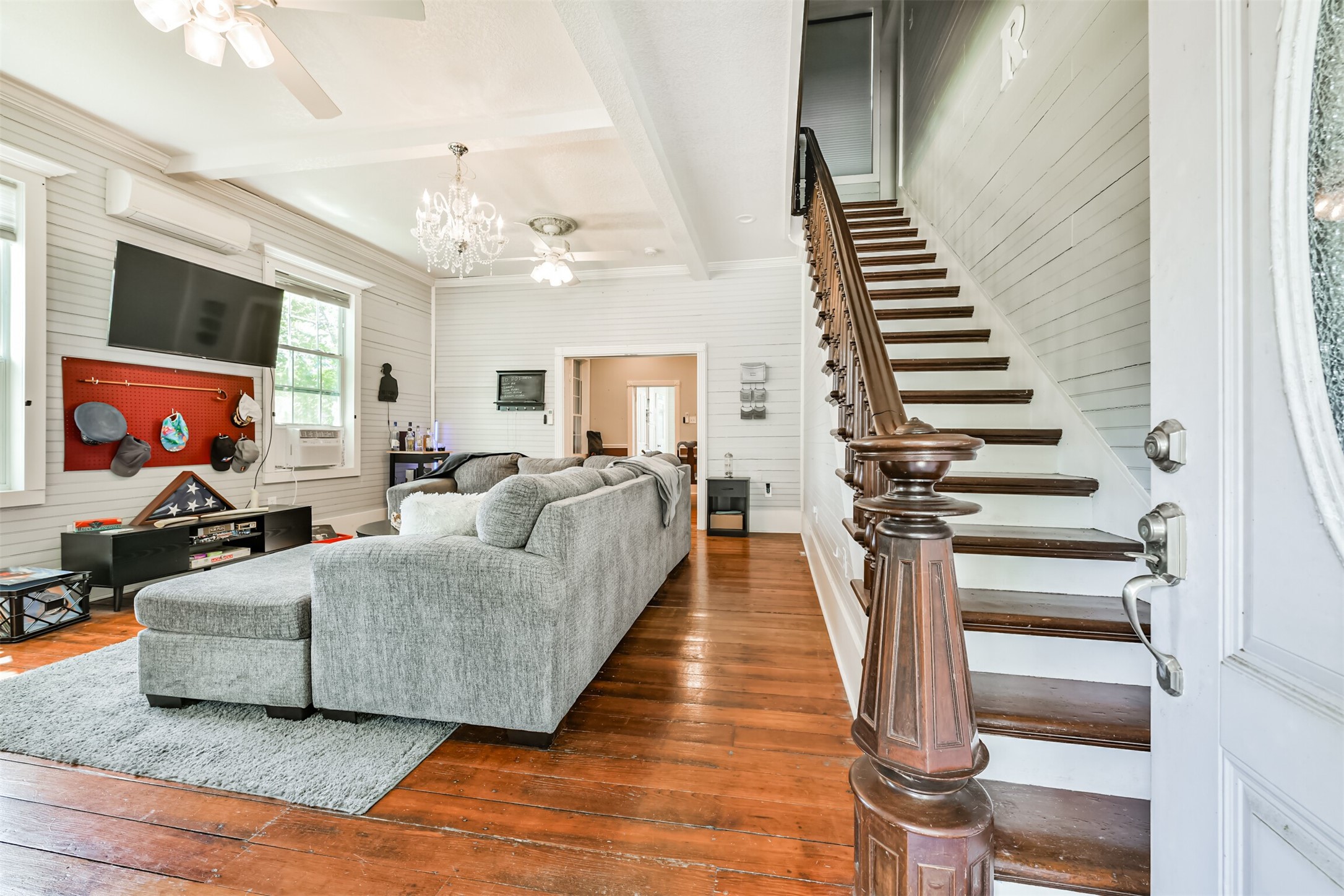 Original hardwood floors and the striking dark walnut staircase immediately steal the show. Original hardwood floors and the striking dark walnut staircase immediately steal the show.