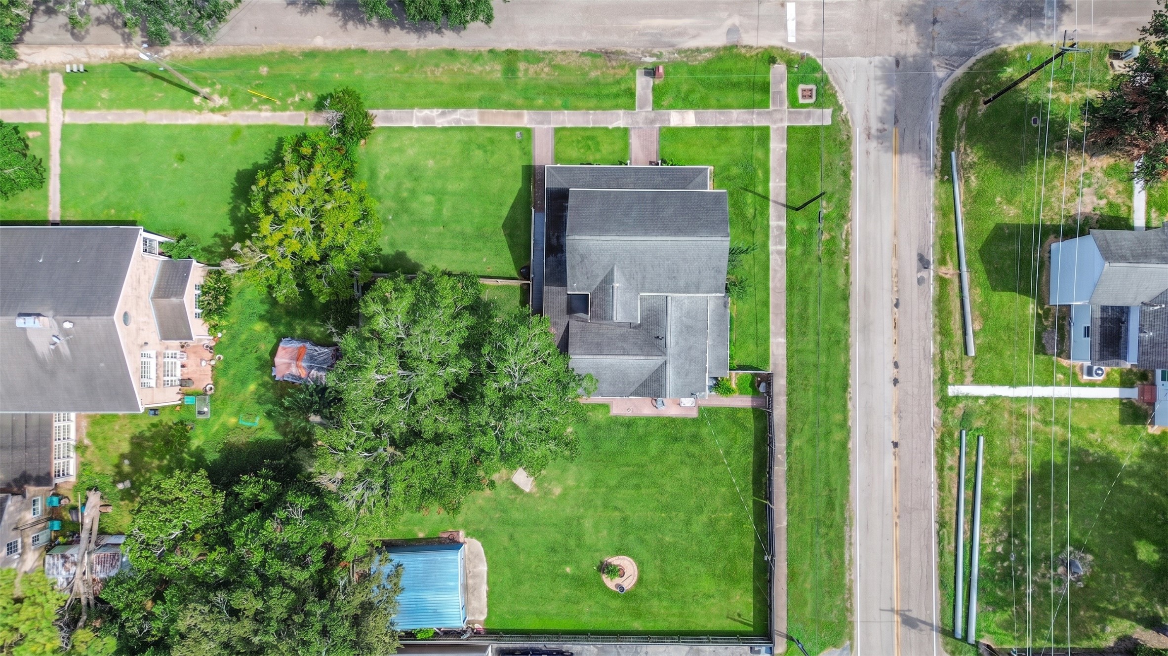Birds-eye view highlights the generous lot and mature trees surrounding the property.