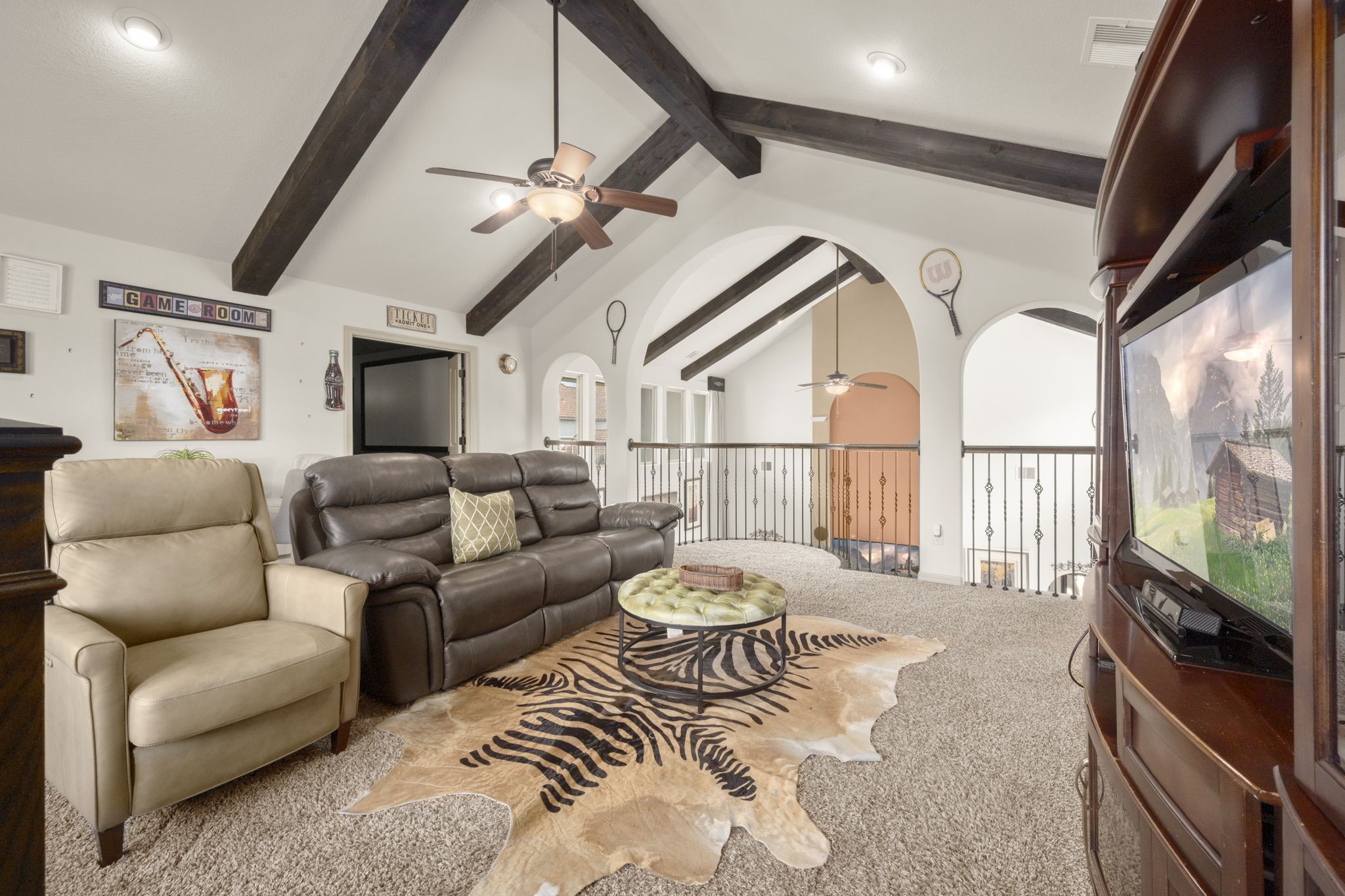 This open and spacious loft features a vaulted ceiling with exposed beams and ample space for seating. This area also gives access to a designated movie room and study nook.