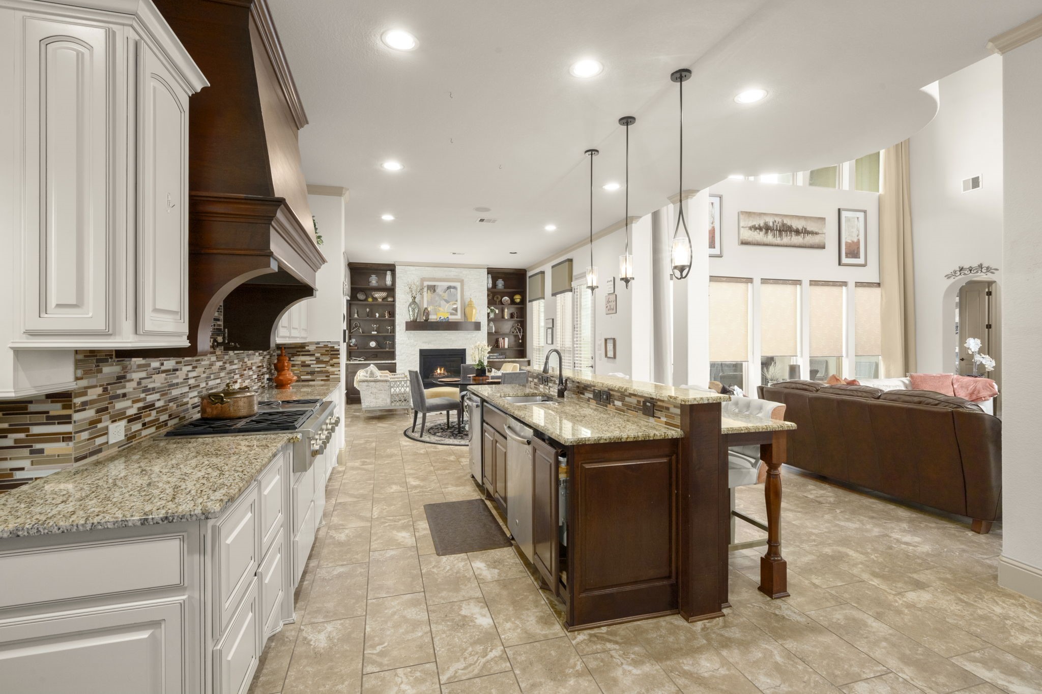 This modern kitchen includes stainless steel appliances, a large island with stylish pendant lighting, a spacious breakfast bar, a walk-in pantry and a secondary kitchenette.