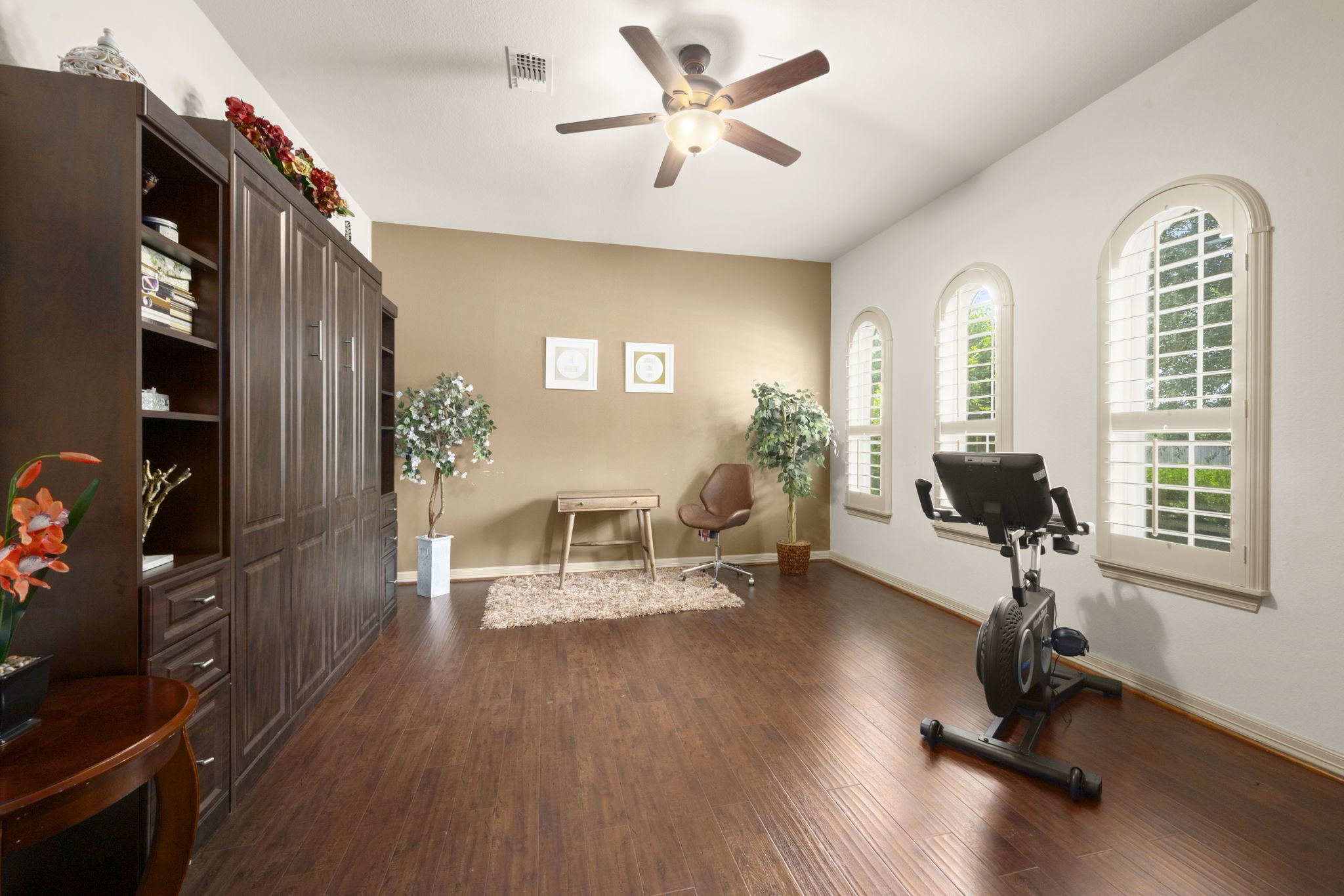 This bright, versatile room features rich wood flooring and built-in shelving - perfect for another home office, gym, or bedroom.