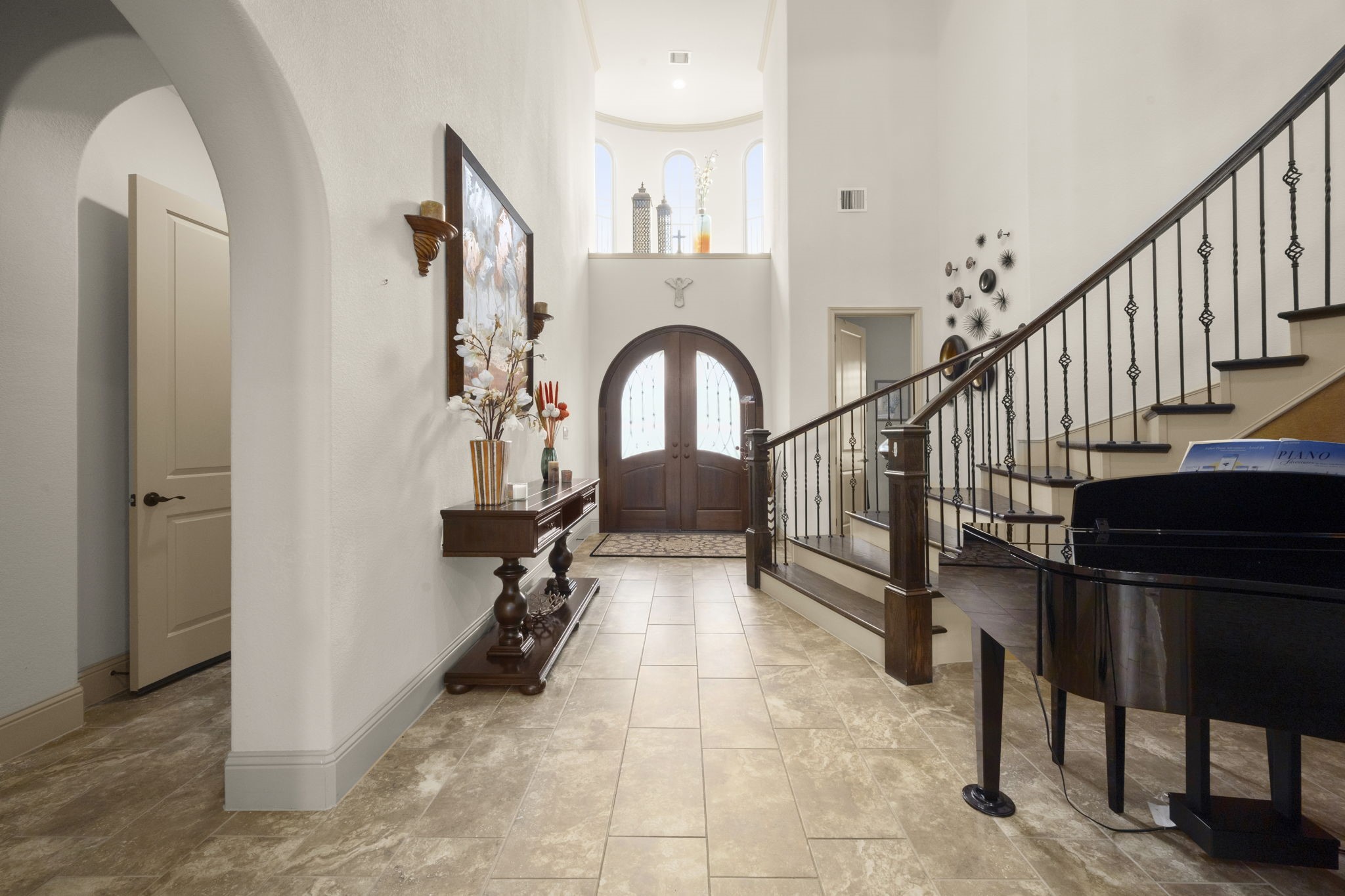 This elegant entryway is enhanced by high ceilings and natural light. Creating a welcoming and luxurious atmosphere.