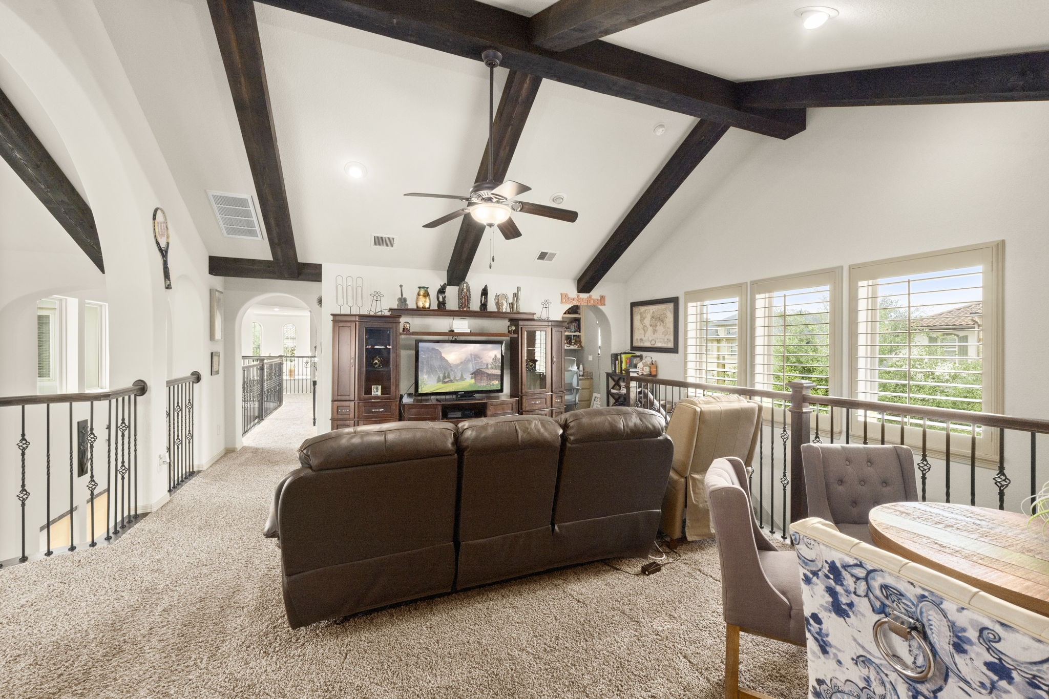 This open and spacious loft features a vaulted ceiling with exposed beams and ample space for seating. This area also gives access to a designated movie room and study nook.