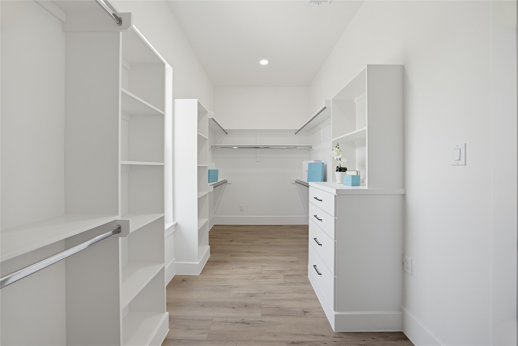Spacious walk-in closet with custom shelving and drawers, offering ample storage and a sleek, modern design.