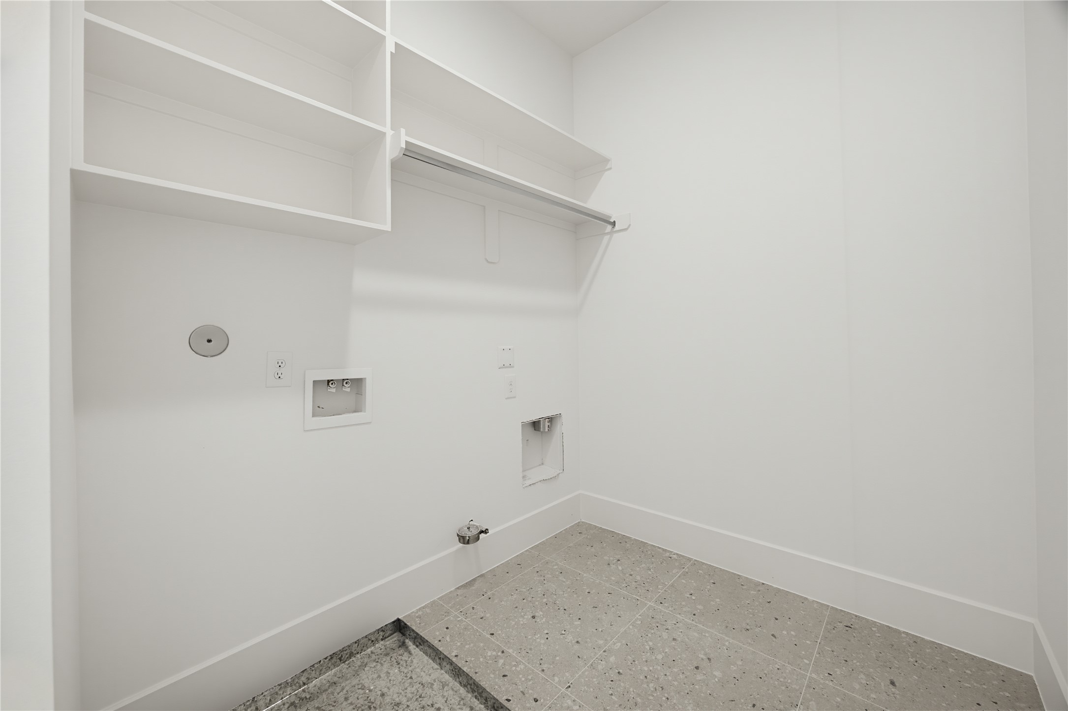 Spacious laundry room with built-in shelving, ample storage, and washer/dryer hookups, perfect for organizing your laundry essentials.