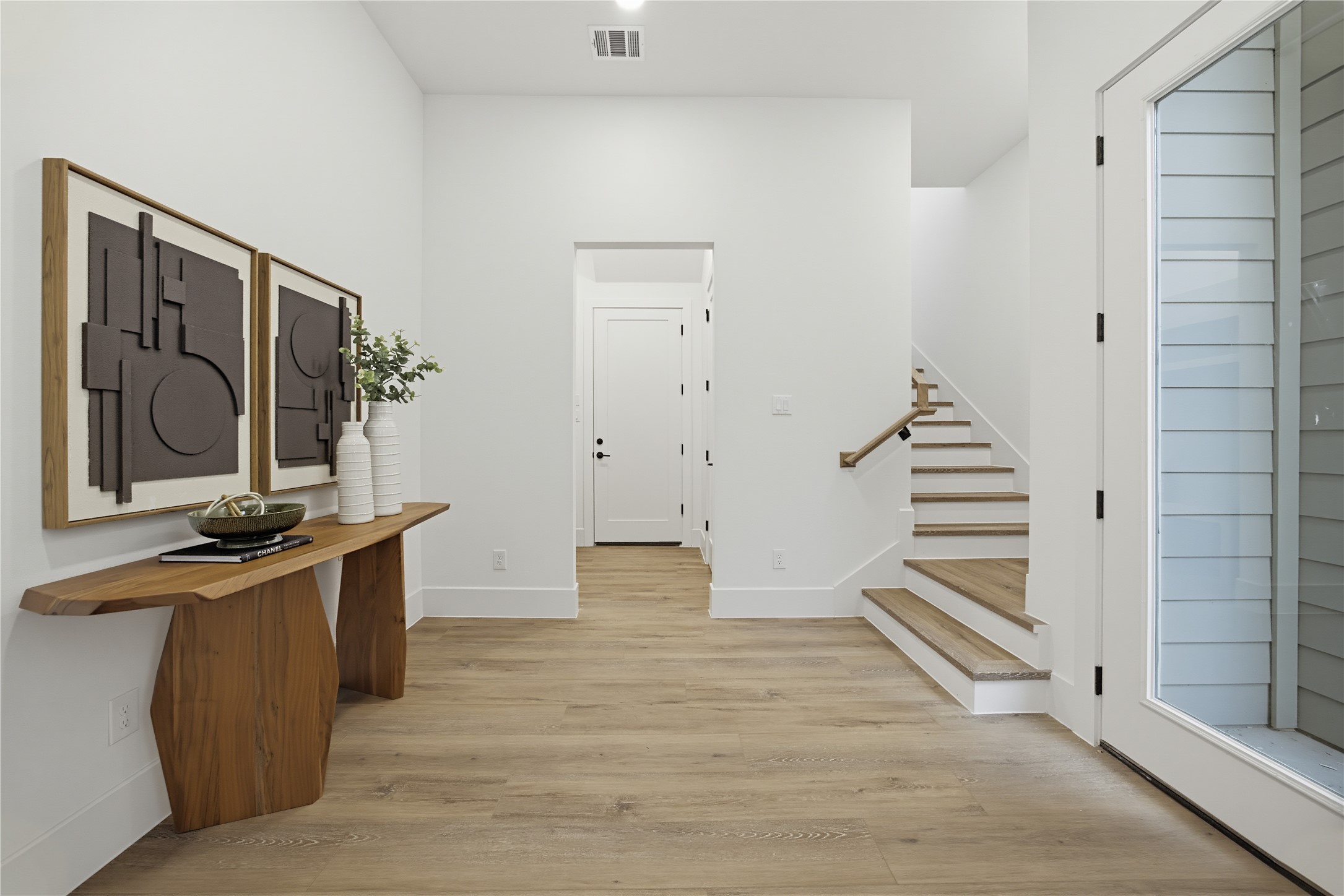 Bright and welcoming foyer and an elegant staircase leading to the upper level.