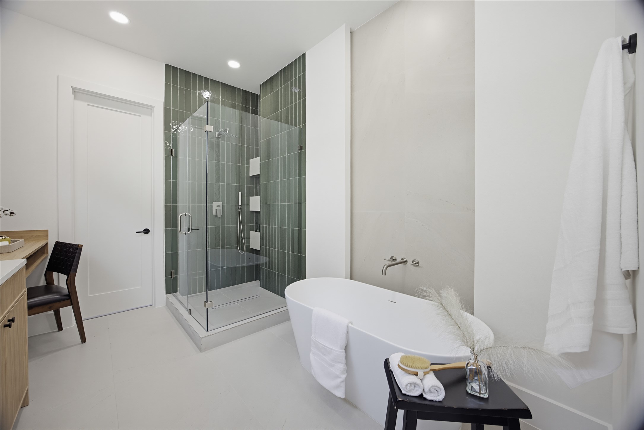 Experience luxury in this modern bathroom featuring a sleek glass-enclosed shower and a freestanding soaking tub. Elegant fixtures and a serene color palette complete the sophisticated look.