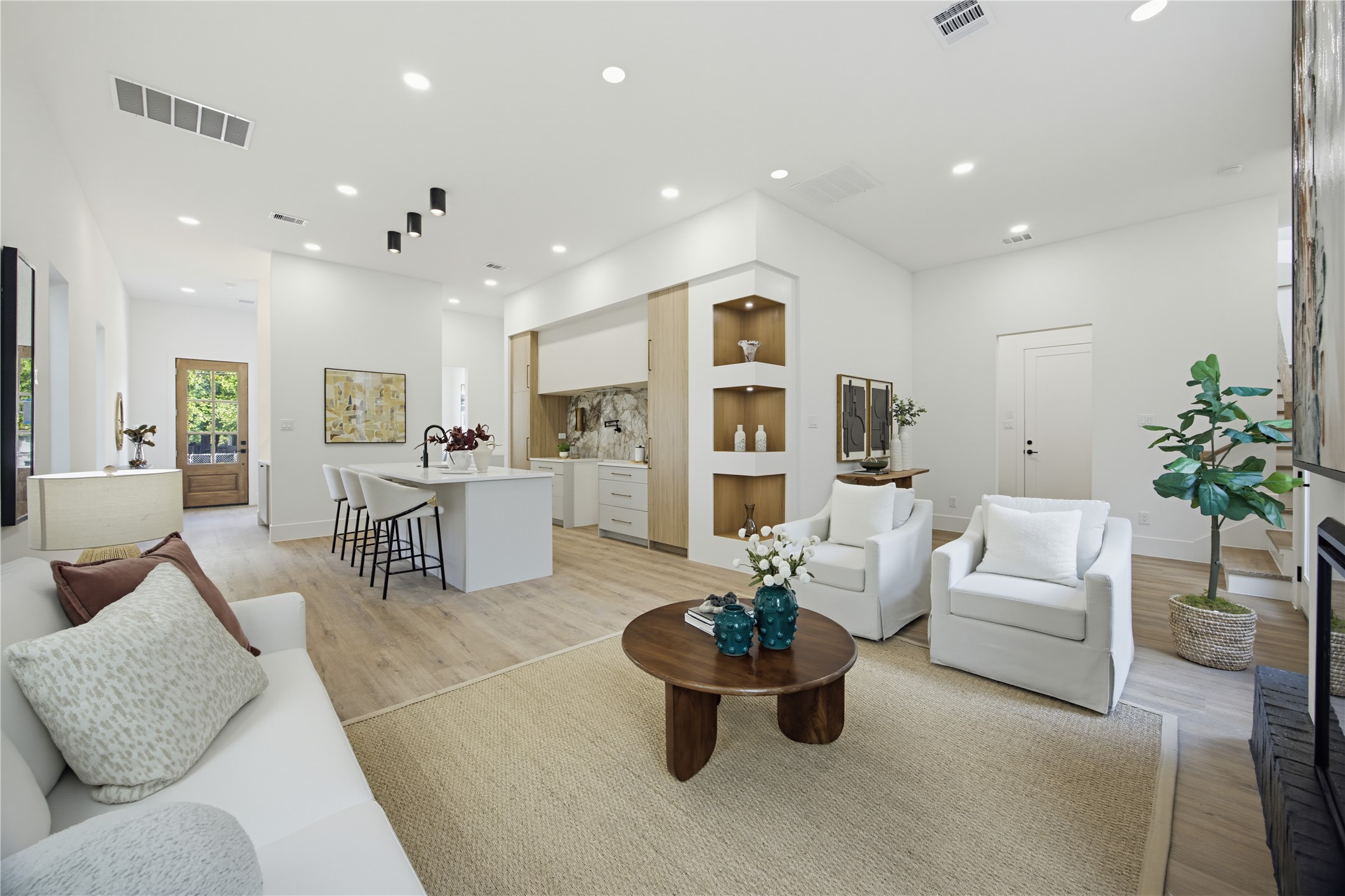 Spacious and modern open-concept living area with sleek hardwood floors, recessed lighting, and a stylish kitchen featuring a large island and contemporary finishes. Perfect for entertaining and relaxation. Spacious and modern open-concept living area with sleek hardwood floors, recessed lighting, and a stylish kitchen featuring a large island and contemporary finishes. Perfect for entertaining and relaxation.