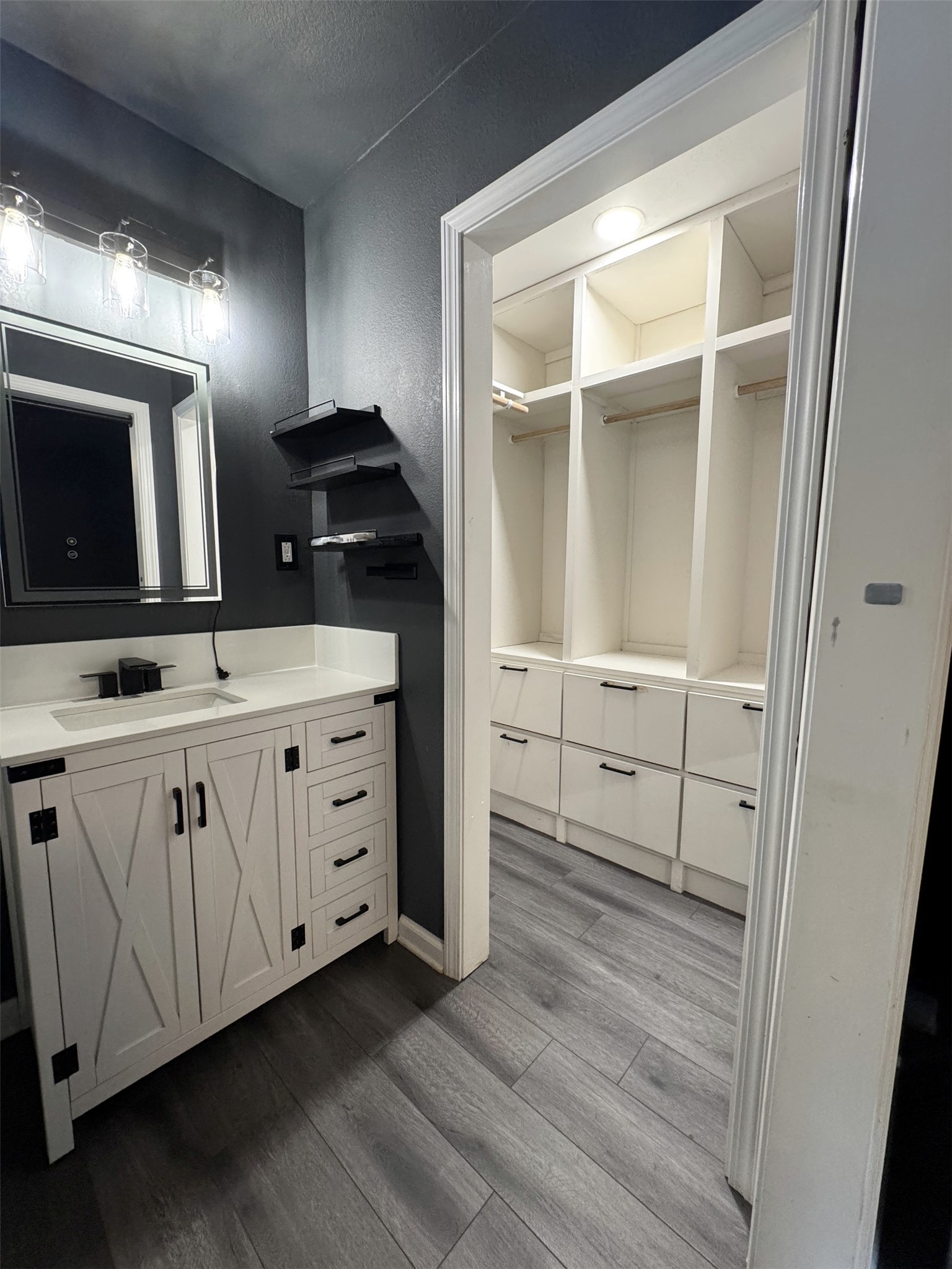 Primary bath looking into walk in closet with built in shelving Primary bath looking into walk in closet with built in shelving