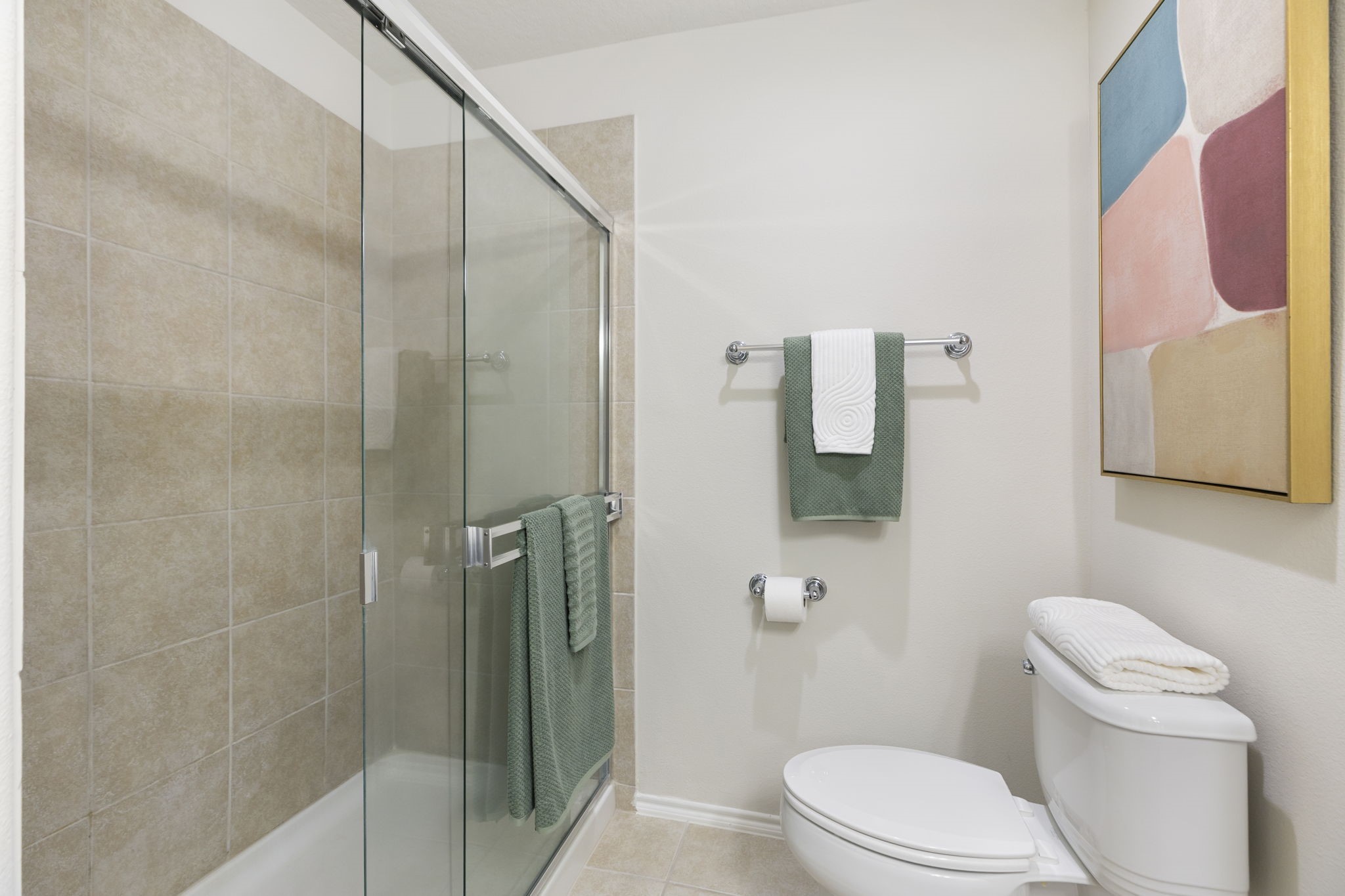 Enjoy long showers in the glass enclosed, low maintenance tiled shower equipped with a dual use showerhead fixture.