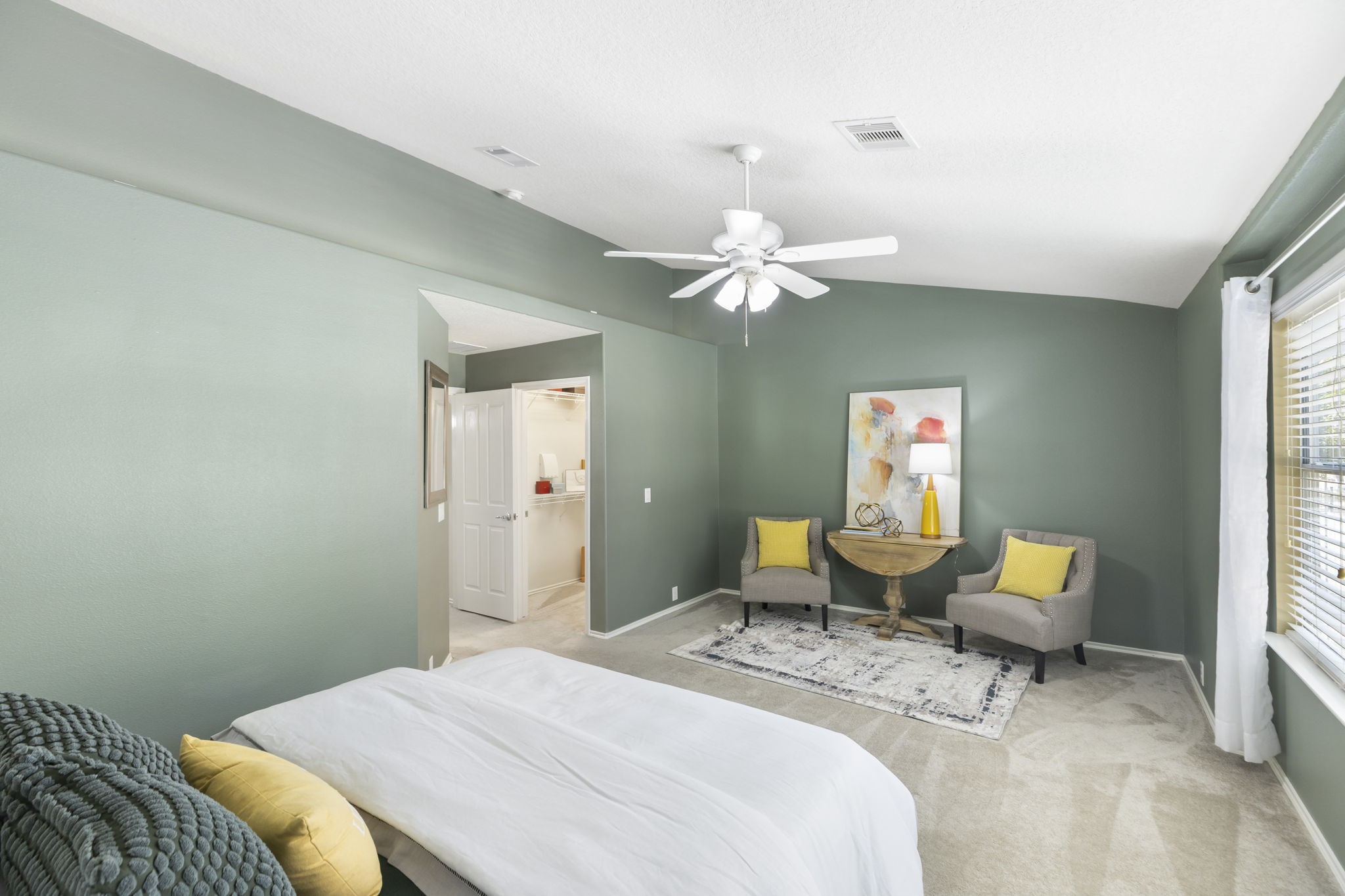 This primary bedroom is thoughtfully designed to create a serene getaway. The room is freshly painted with a soothing green palette and accent LED lighting on the ledge to create a relaxed and romantic mood.