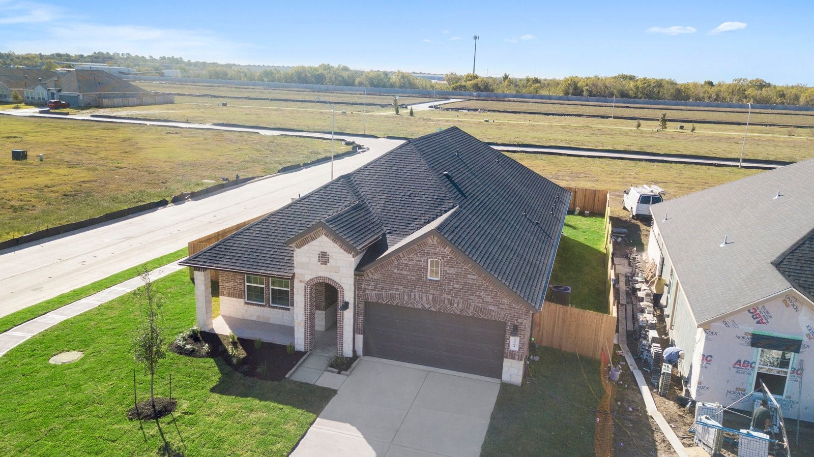 Newly built single story home with traditional architecture, a garage, and landscaped front yard.