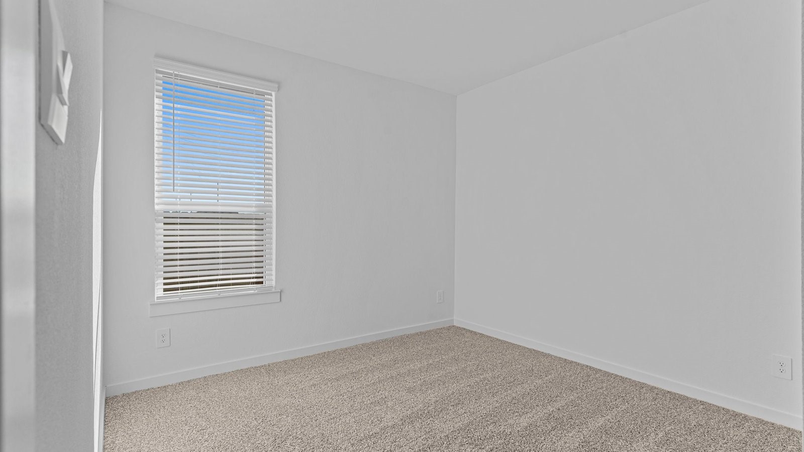 A second bedroom with neutral toned walls, carpet flooring and a separate closet.