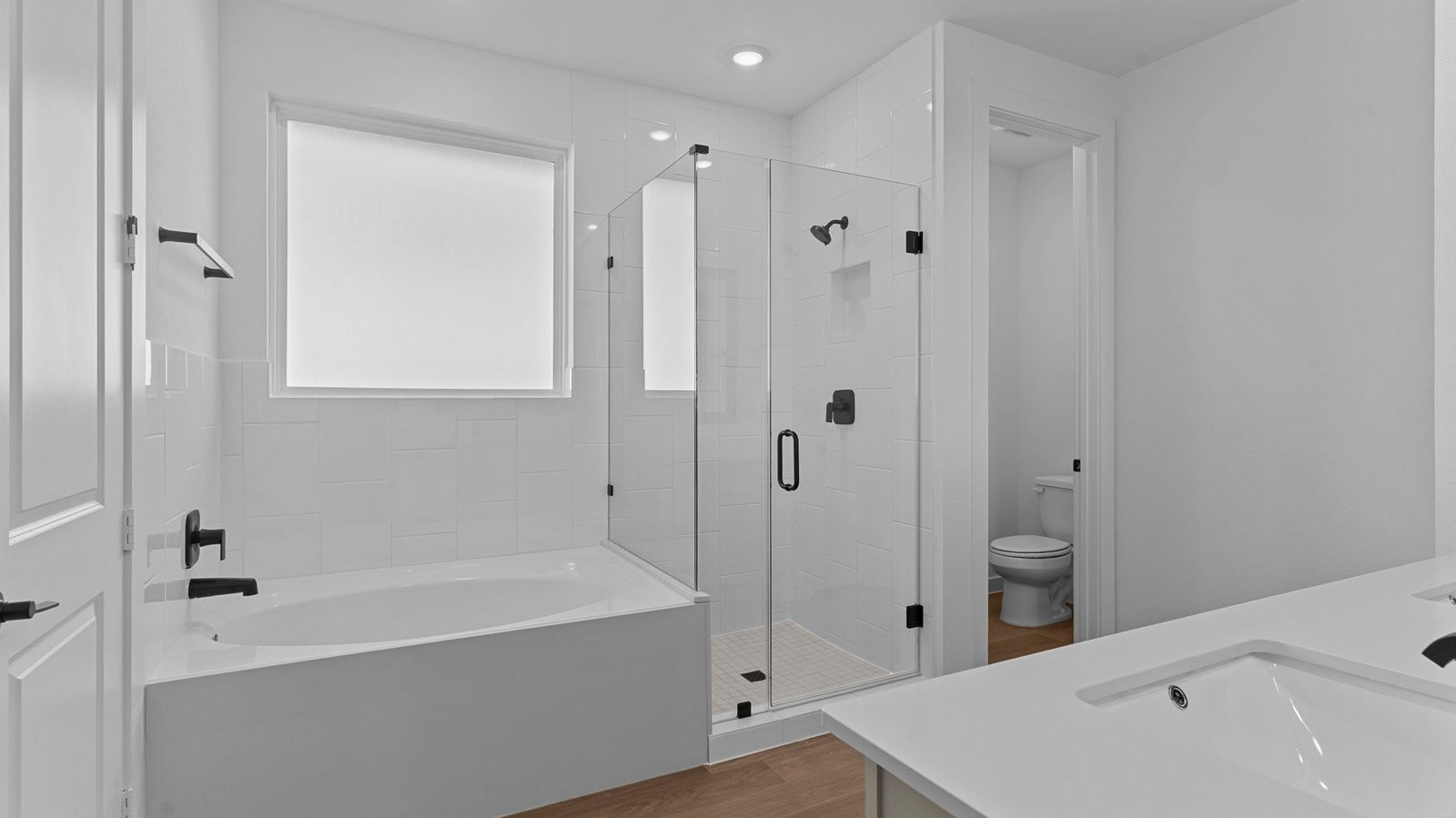 Primary bathroom with a glass-enclosed standing shower and separate soaking tub.