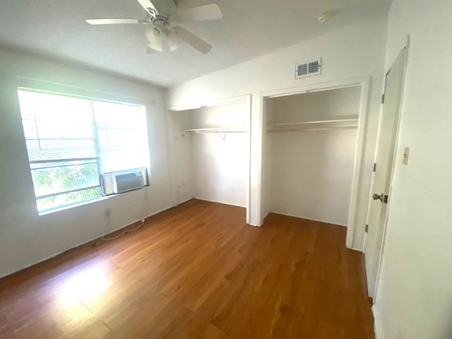 Primary bedroom is spacious with ac window unit and extra closet space.